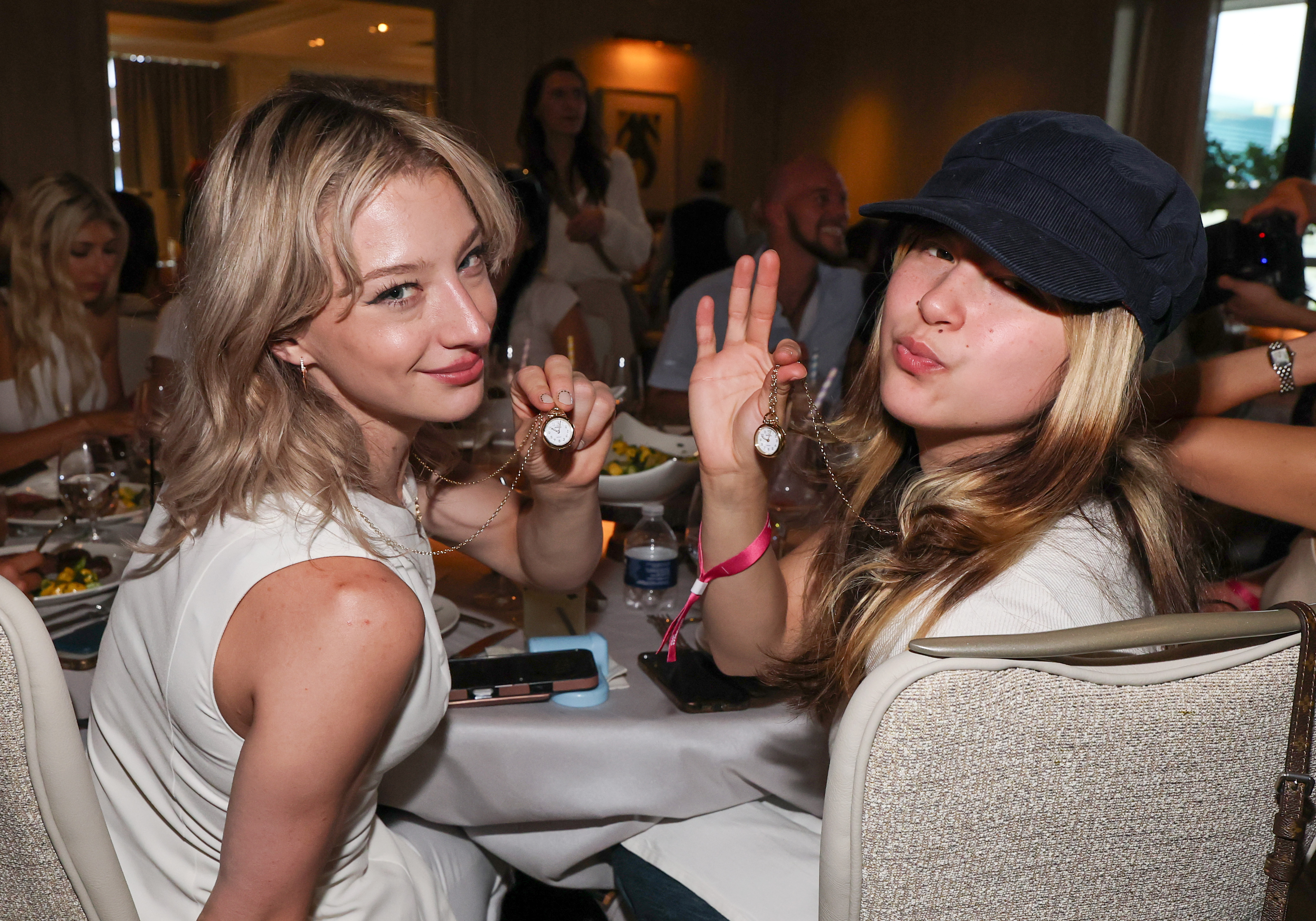 Click to open the image gallery Figure skaters Amber Glenn and Alysa Liu showing off Shinola clock necklaces gifted by Flavor Flav at a Las Vegas athlete dinner