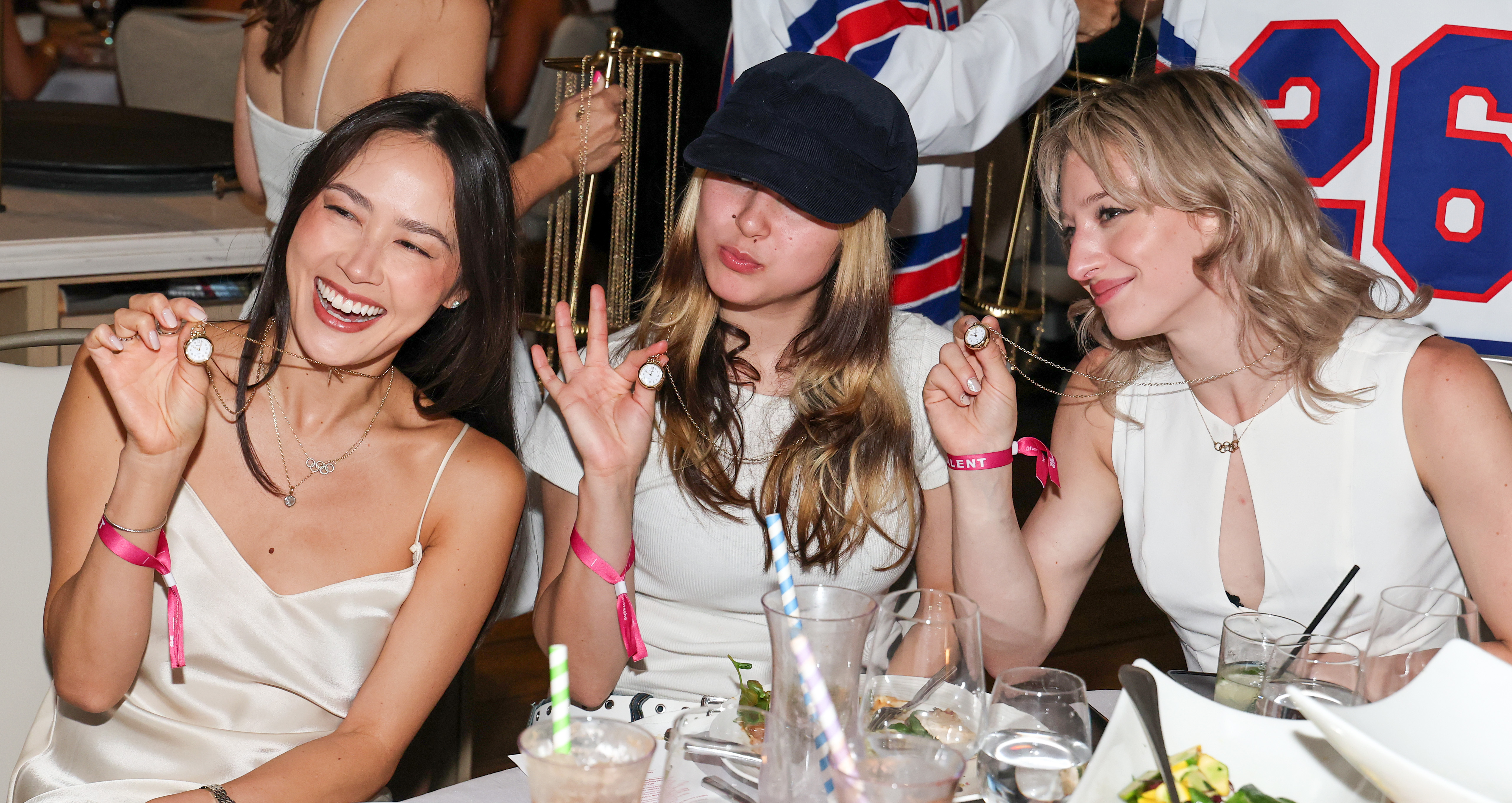 Click to open the image gallery Figure skaters Madison Chock, Alysa Liu, and Amber Glenn wearing Shinola clock necklaces at a Las Vegas dinner