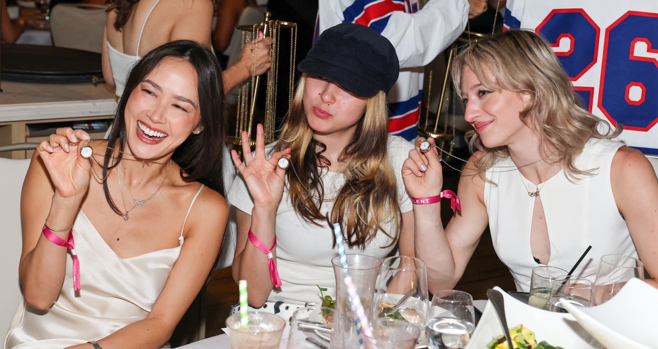 Figure skaters Madison Chock, Alysa Liu, and Amber Glenn wearing Shinola clock necklaces at a Las Vegas dinner