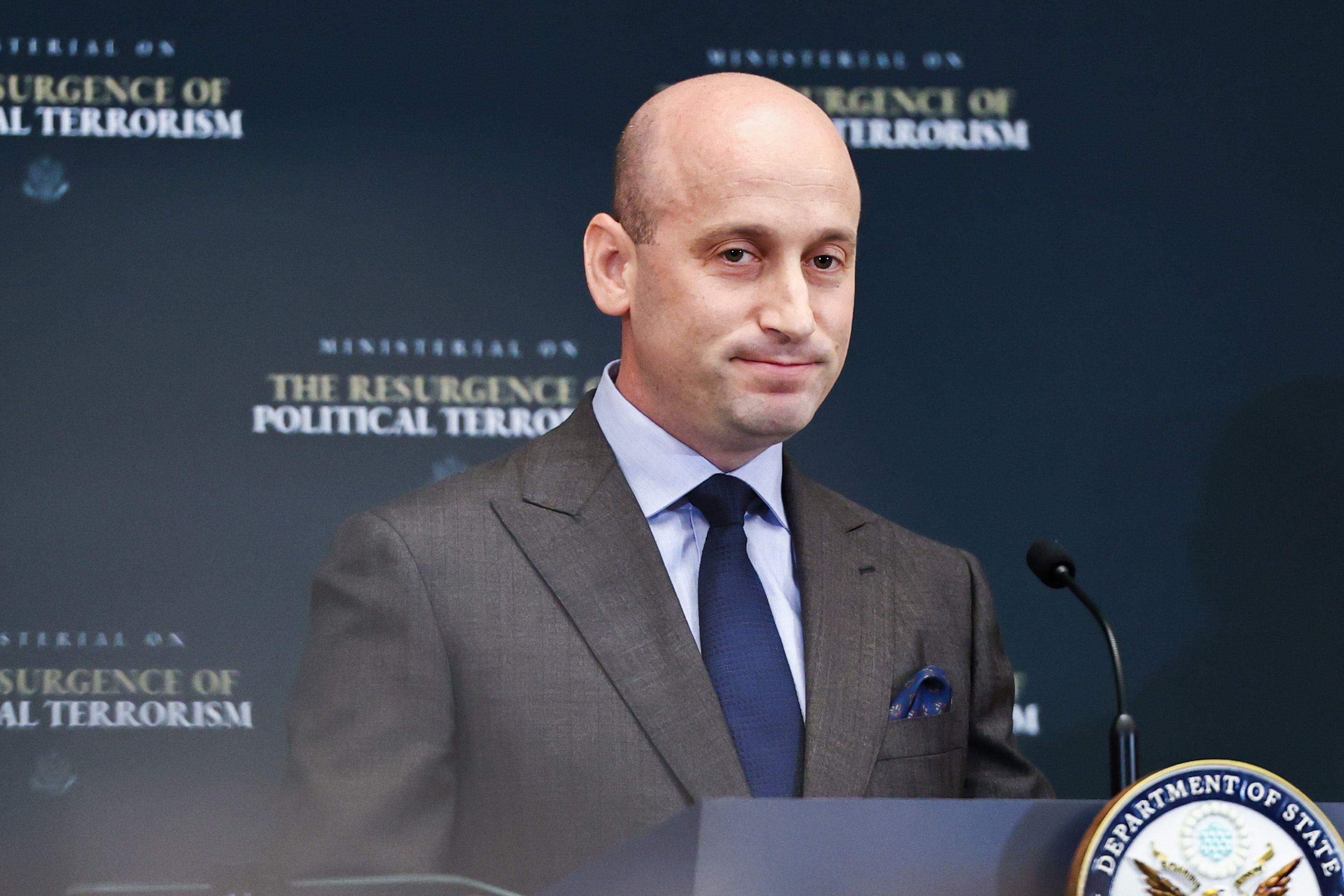 Stephen Miller speaking at a podium during a State Department ministerial event in Washington, DC