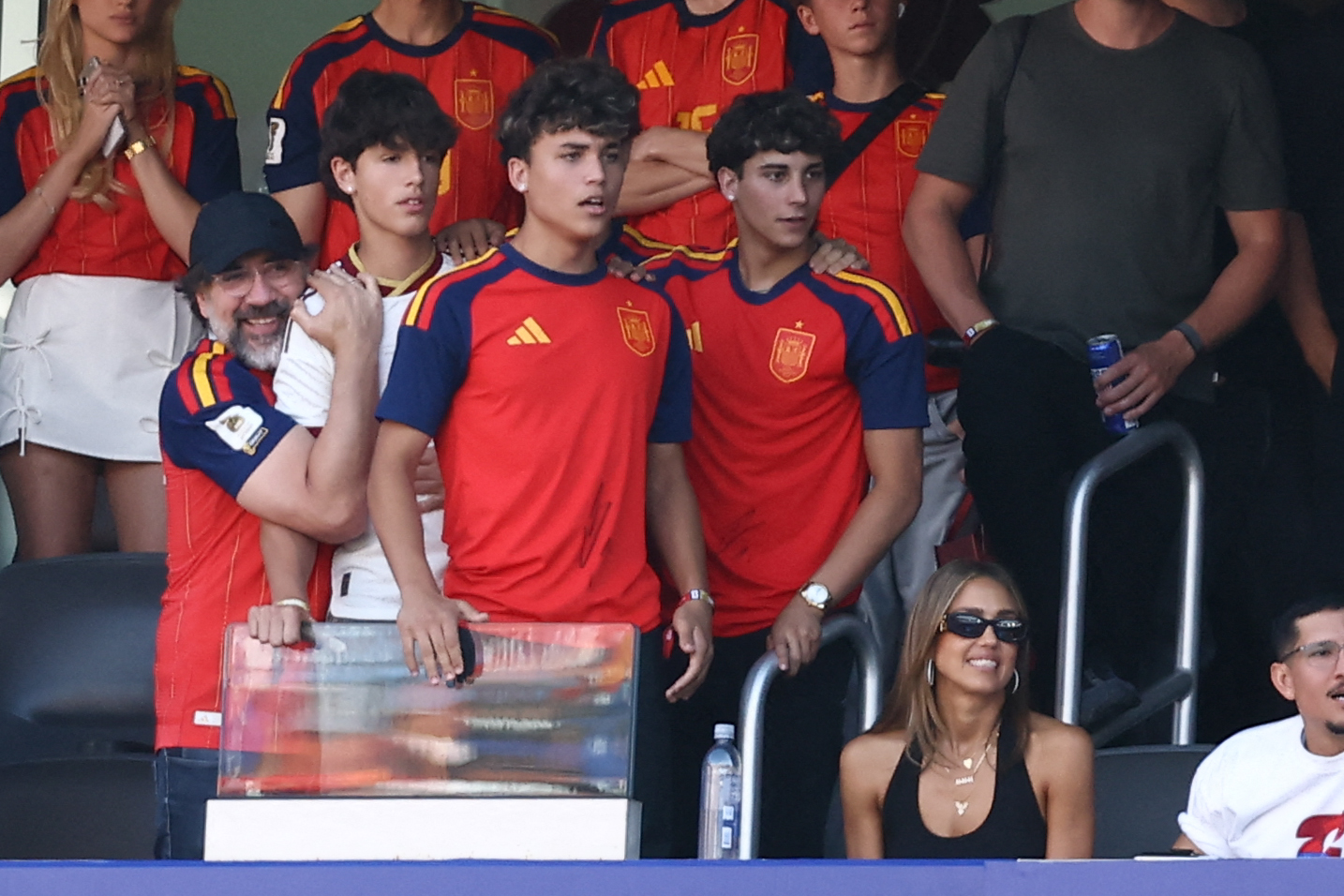 Jessica Alba and Javier Bardem cheering in the stands at the 2026 FIFA World Cup final between Spain and Argentina at MetLife Stadium