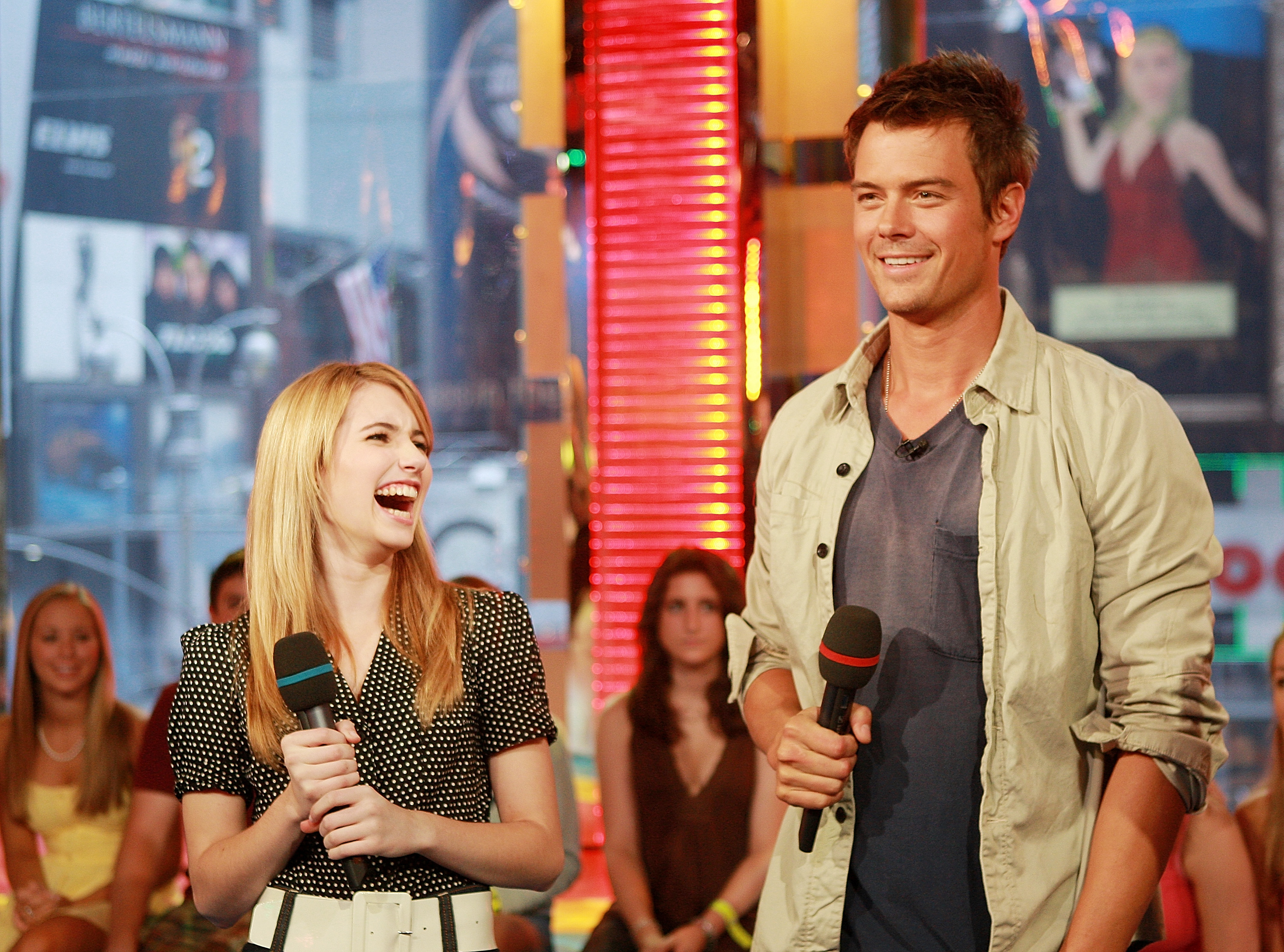 Click to open the image gallery Emma Roberts laughing and Josh Duhamel smiling while holding microphones on the set of MTV's Total Request Live.