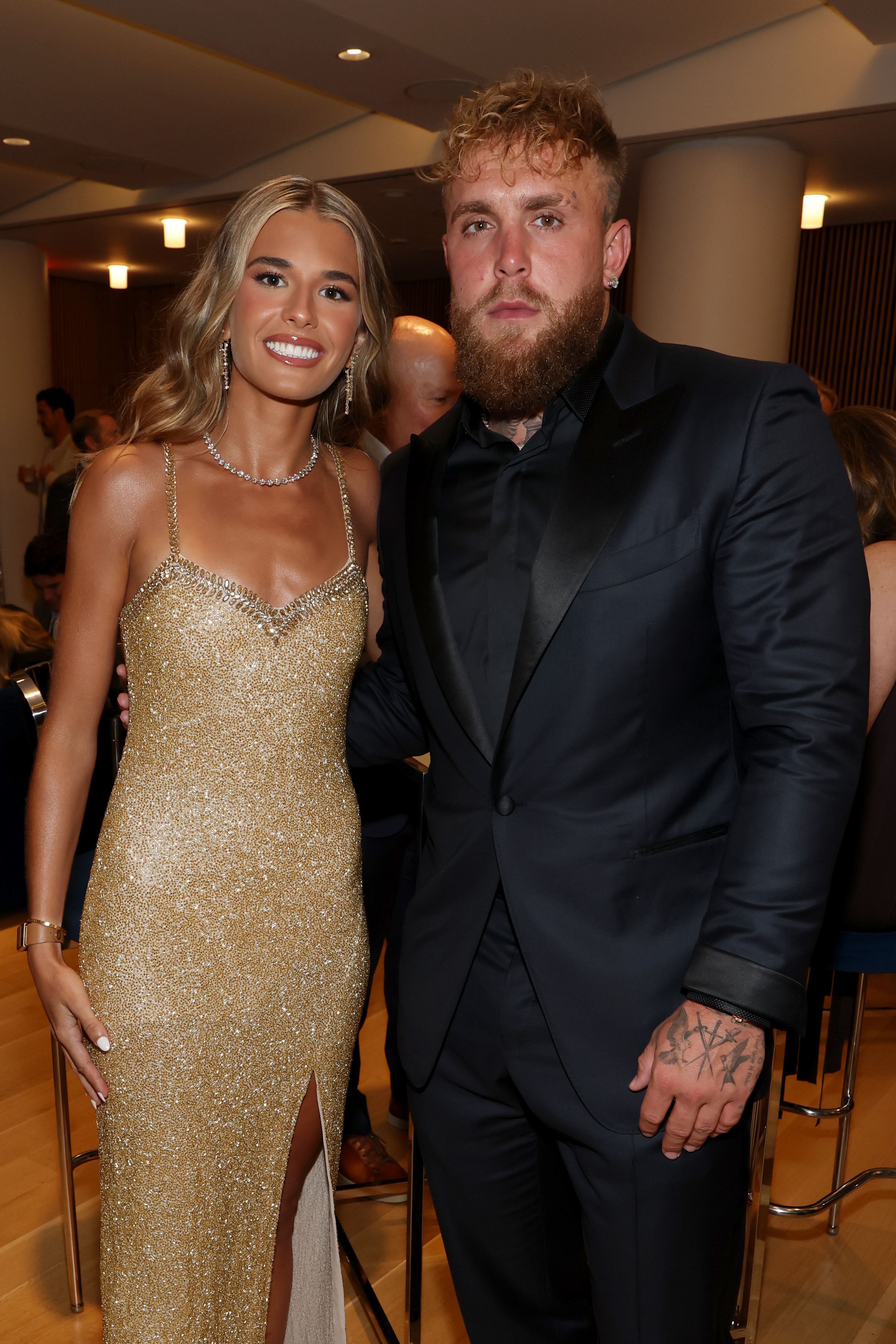 Kai Trump in a gold sequin gown standing next to Jake Paul in a dark suit, posing together backstage at the 2026 ESPY Awards.