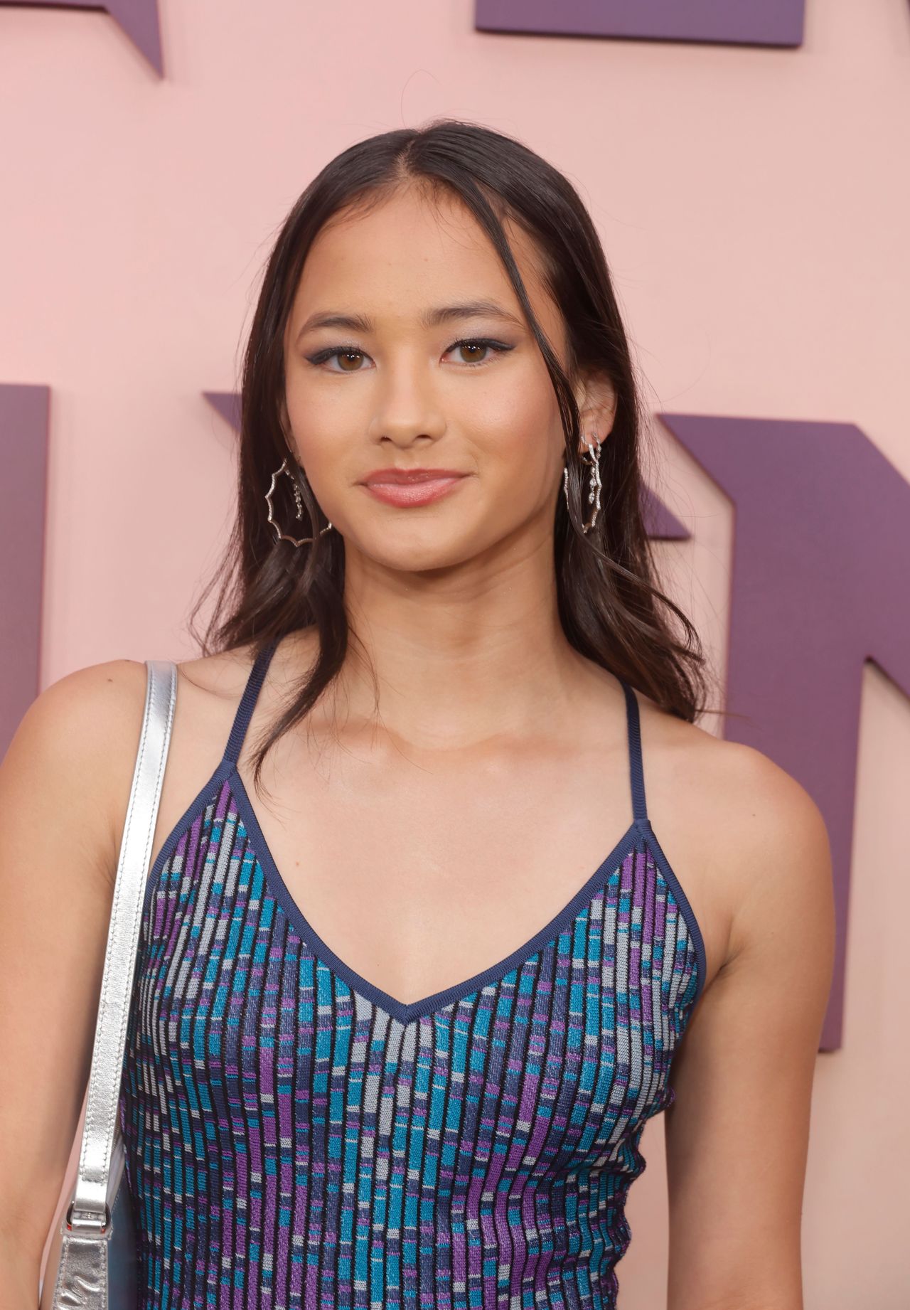 Kaylee Hottle in a blue, purple, and teal patterned spaghetti-strap dress at the Godzilla X Kong premiere in Hollywood.