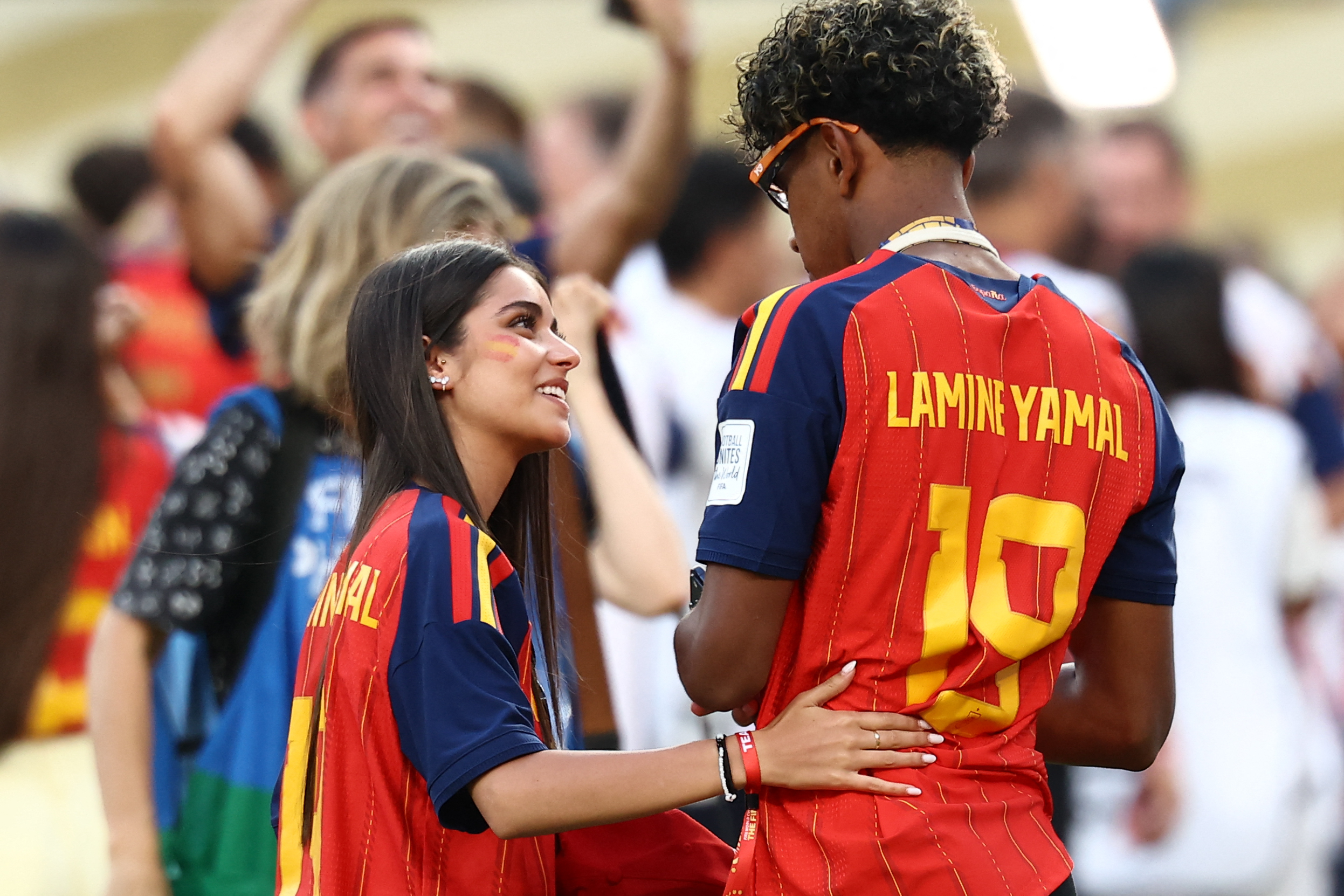 Lamine Yamal celebrating with partner Ines Garcia on the field after Spain wins the 2026 FIFA World Cup final