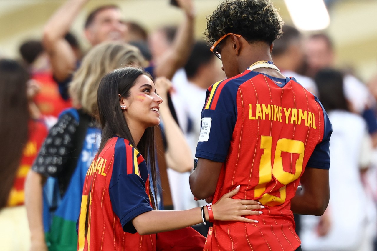 Lamine Yamal celebrating with partner Ines Garcia on the field after Spain wins the 2026 FIFA World Cup final