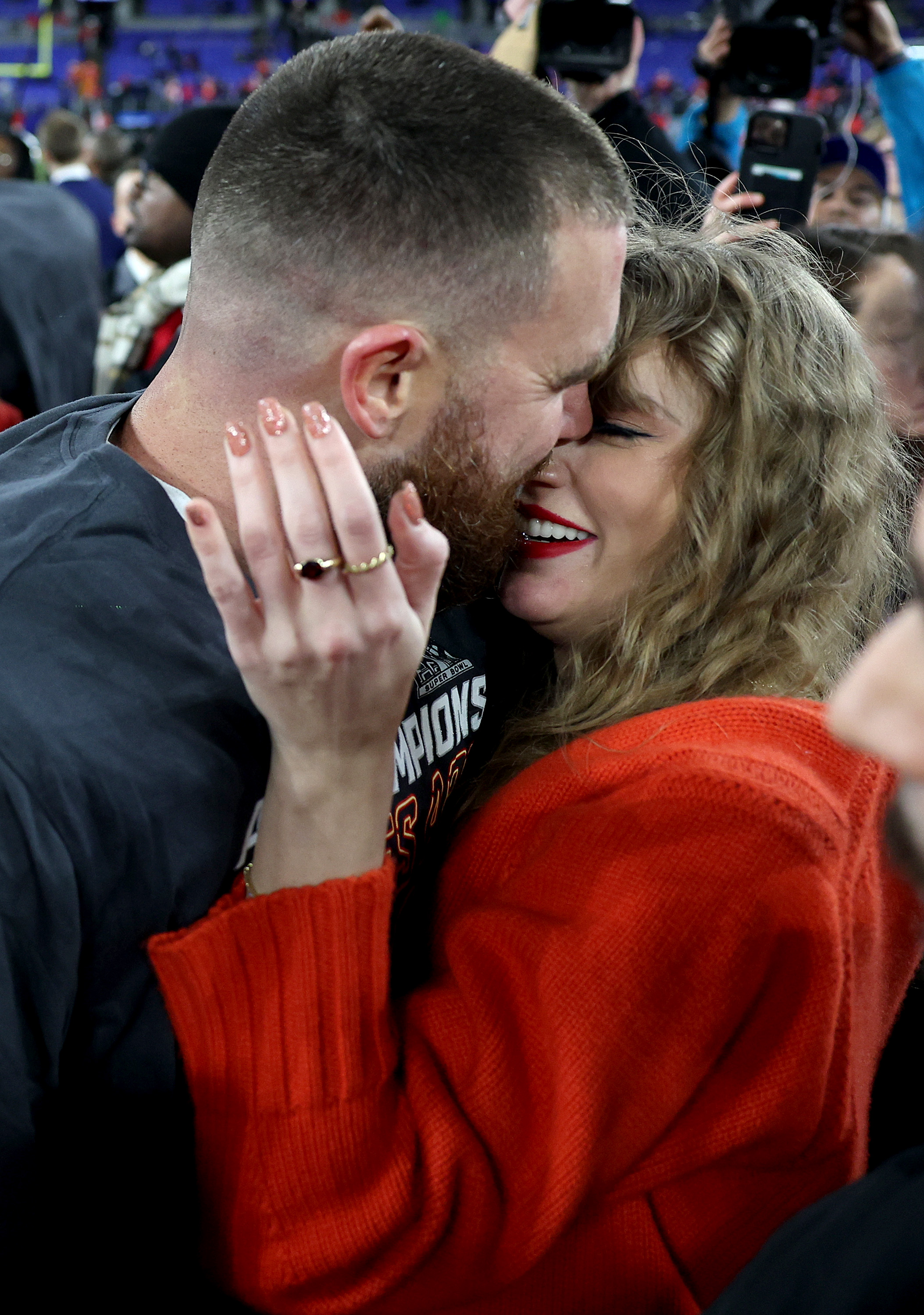 Travis Kelce and Taylor Swift embracing on the field after the AFC Championship Game at M&T Bank Stadium
