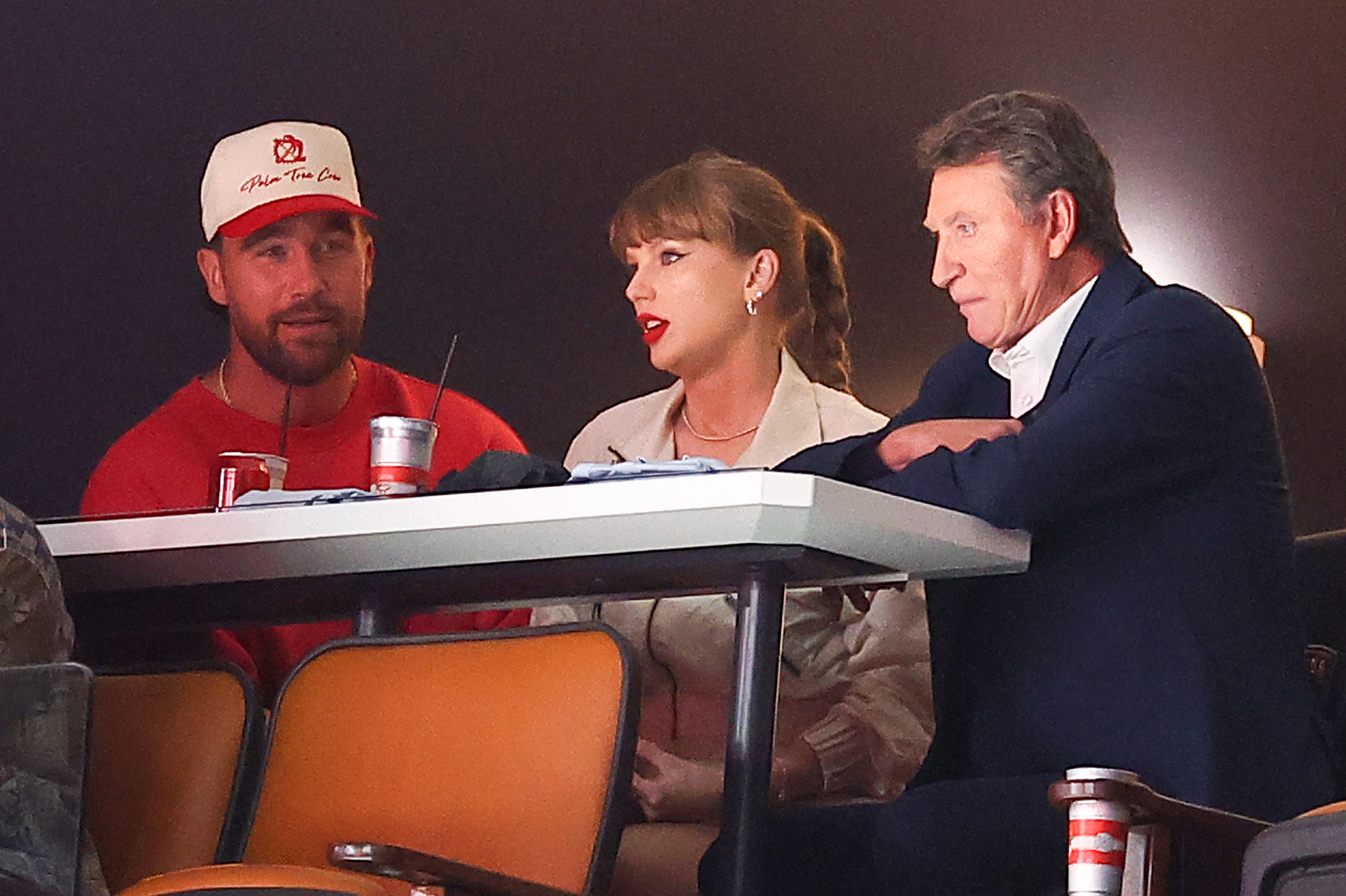 Travis Kelce, Taylor Swift, and Wayne Gretzky seated together in the stands at Game Four of the 2025 Stanley Cup Final