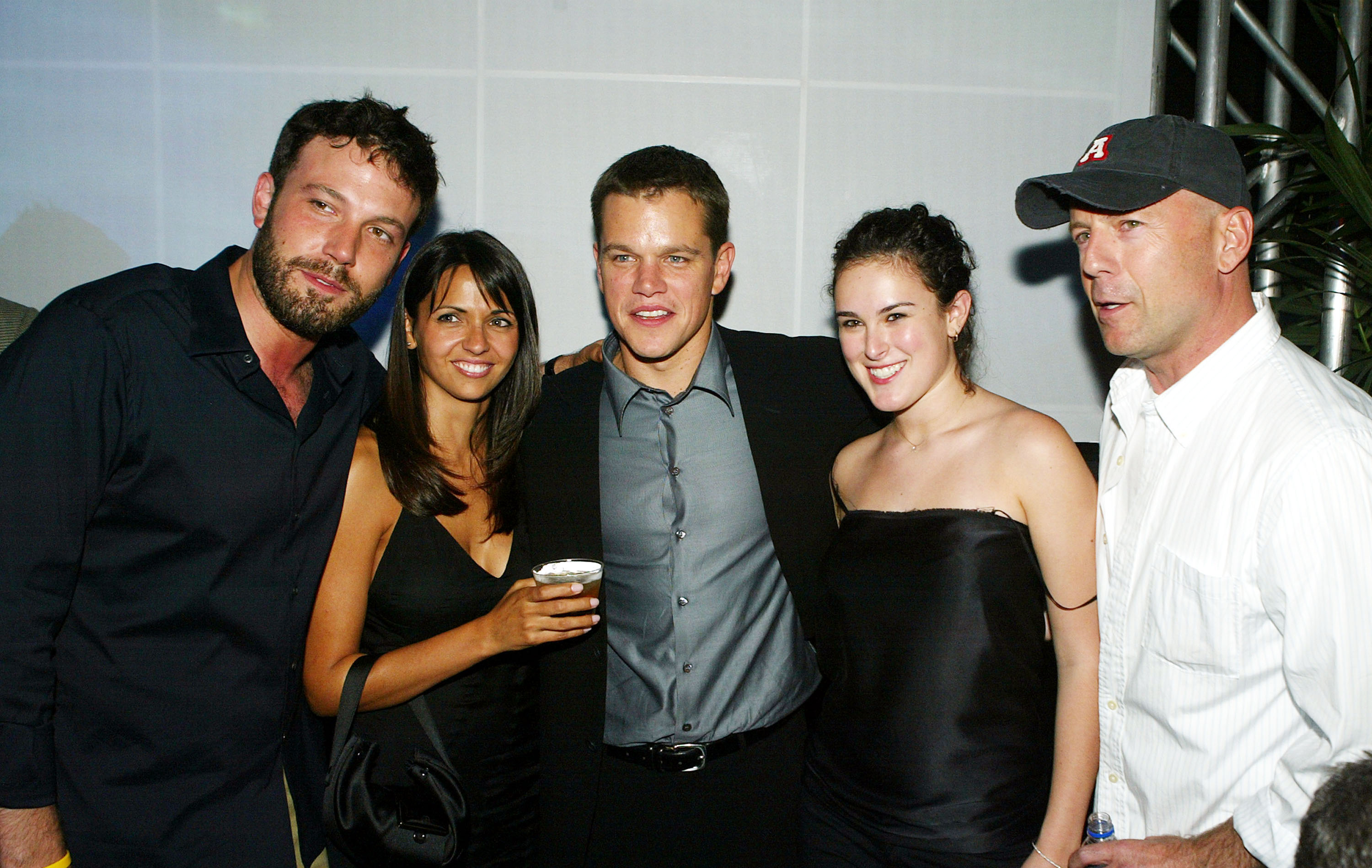 Click to open the image gallery Matt Damon, Luciana Bozan, Bruce Willis, Rumer Willis, and Ben Affleck posing together at The Bourne Supremacy after party in Los Angeles, 2004