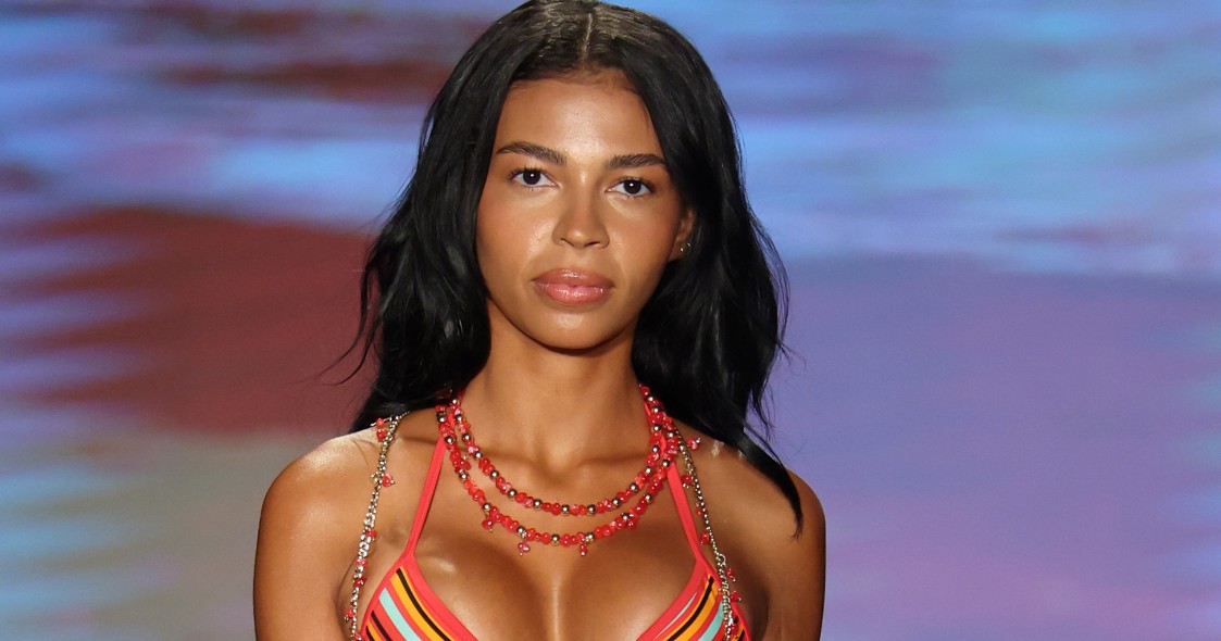 Layla Taylor walking the runway in a striped bikini with draped chain and bead embellishments at Paraiso Miami Swim Week 2026.
