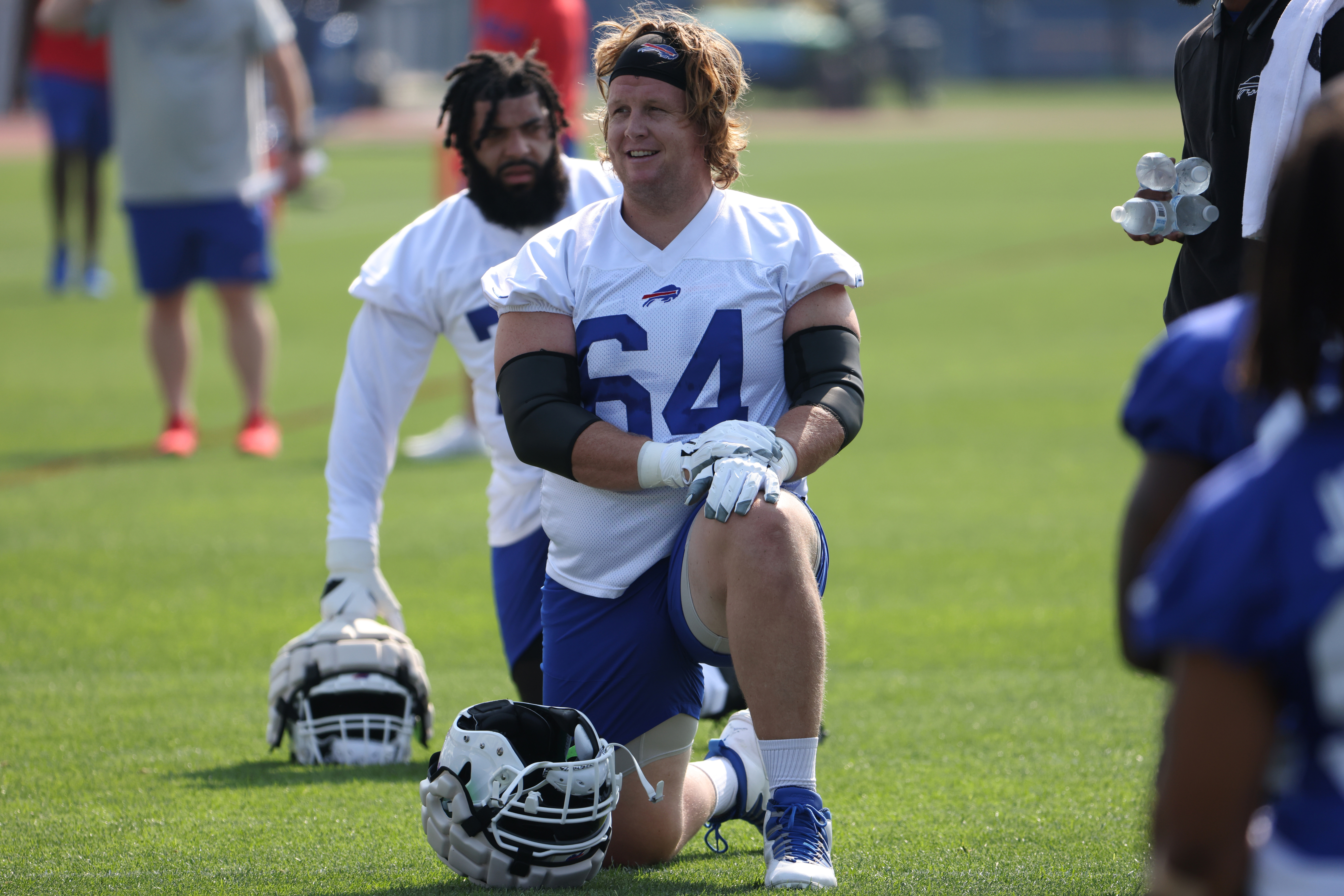 Jordan Devey wearing number 64 stretches on the field at Buffalo Bills training camp in Orchard Park, NY
