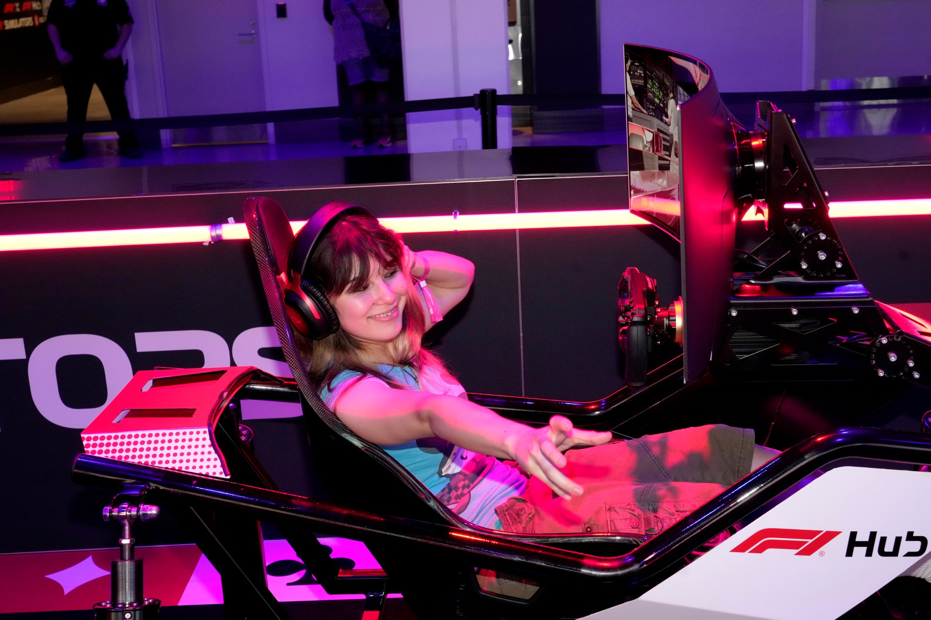 Alysa Liu seated in an F1 simulator at the F1 Paddock at Grand Prix Plaza in Las Vegas during Flavor Flav's SheWeekend