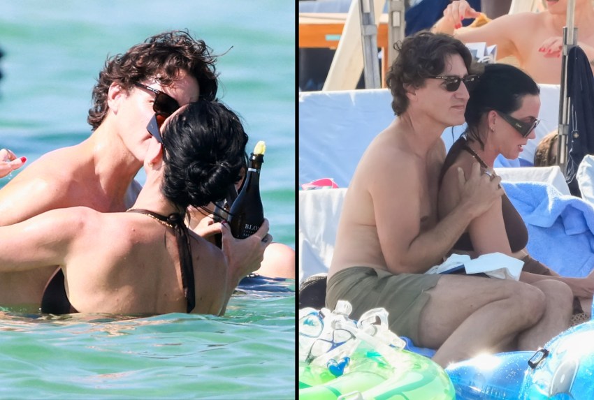 Two people kissing in the ocean, one holding a dark wine bottle, with a rubber dinghy visible in the background.