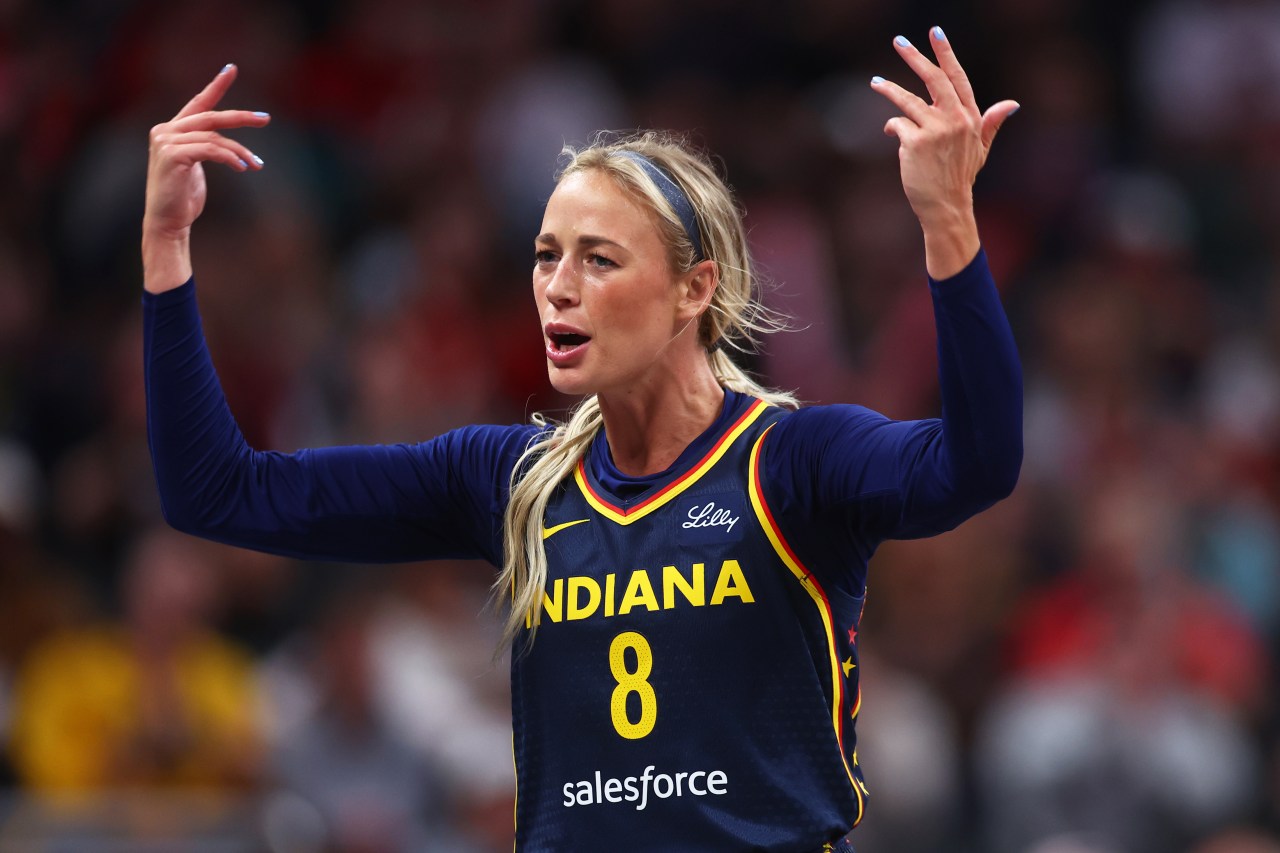 Indiana Fever player Sophie Cunningham, wearing number 8, raises both hands and reacts emotionally during a WNBA game against the Washington Mystics.