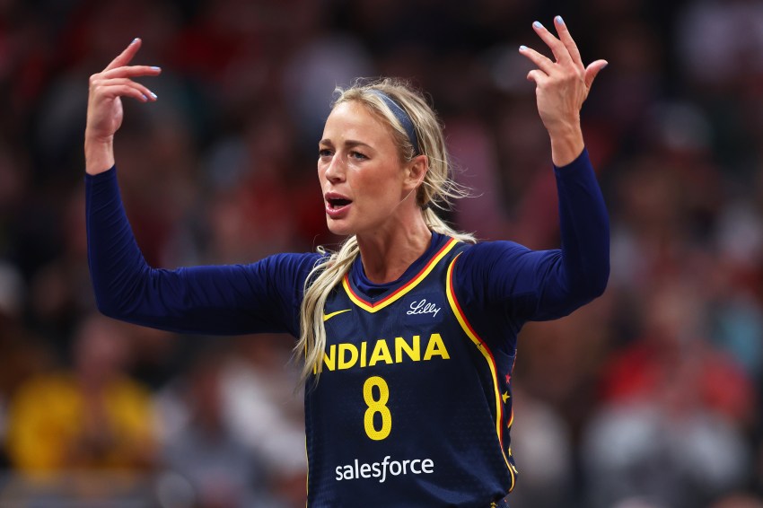 Indiana Fever player Sophie Cunningham, wearing number 8, raises both hands and reacts emotionally during a WNBA game against the Washington Mystics.