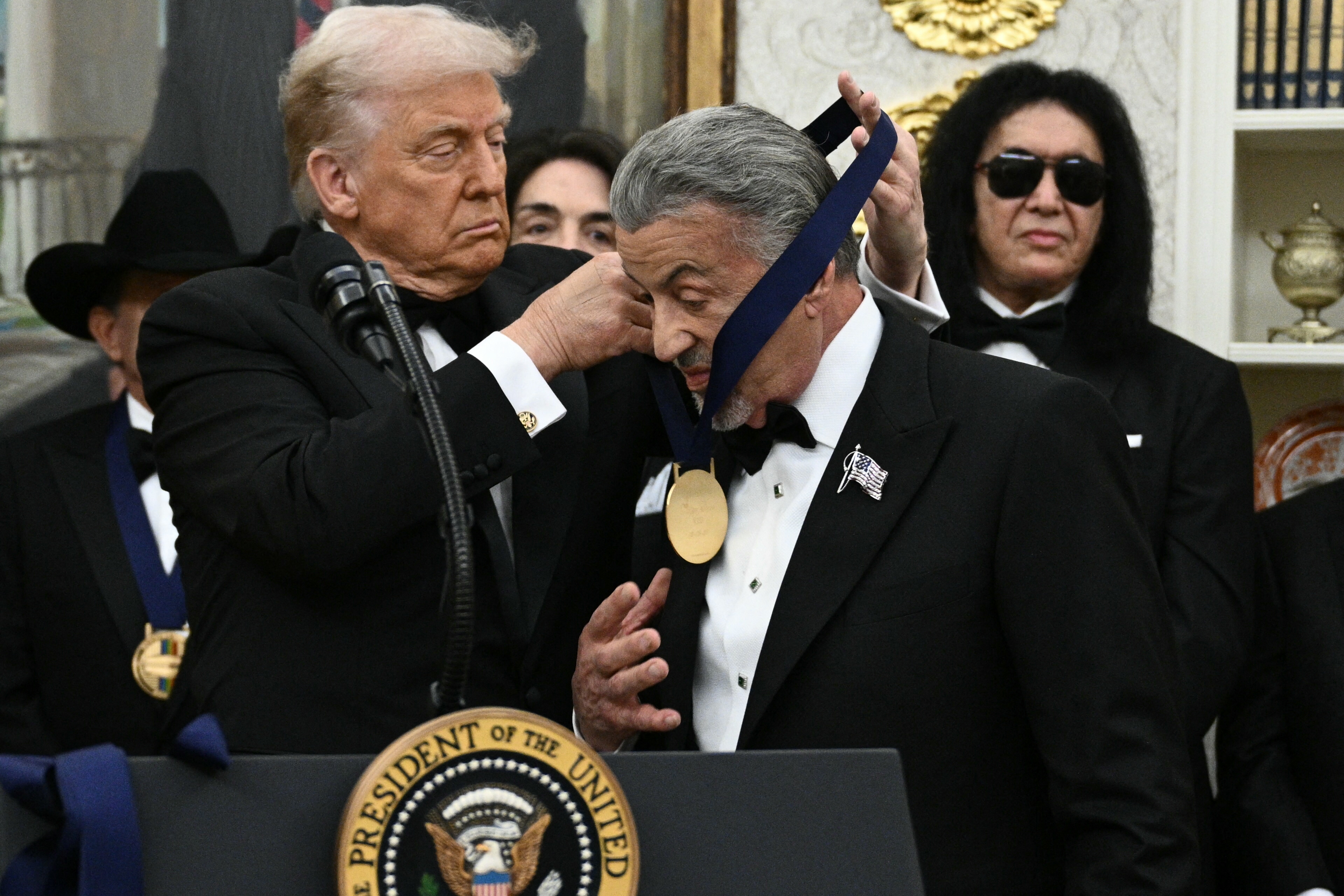 Sylvester Stallone receiving a Kennedy Center Honors medal from President Donald Trump in the Oval Office of the White House
