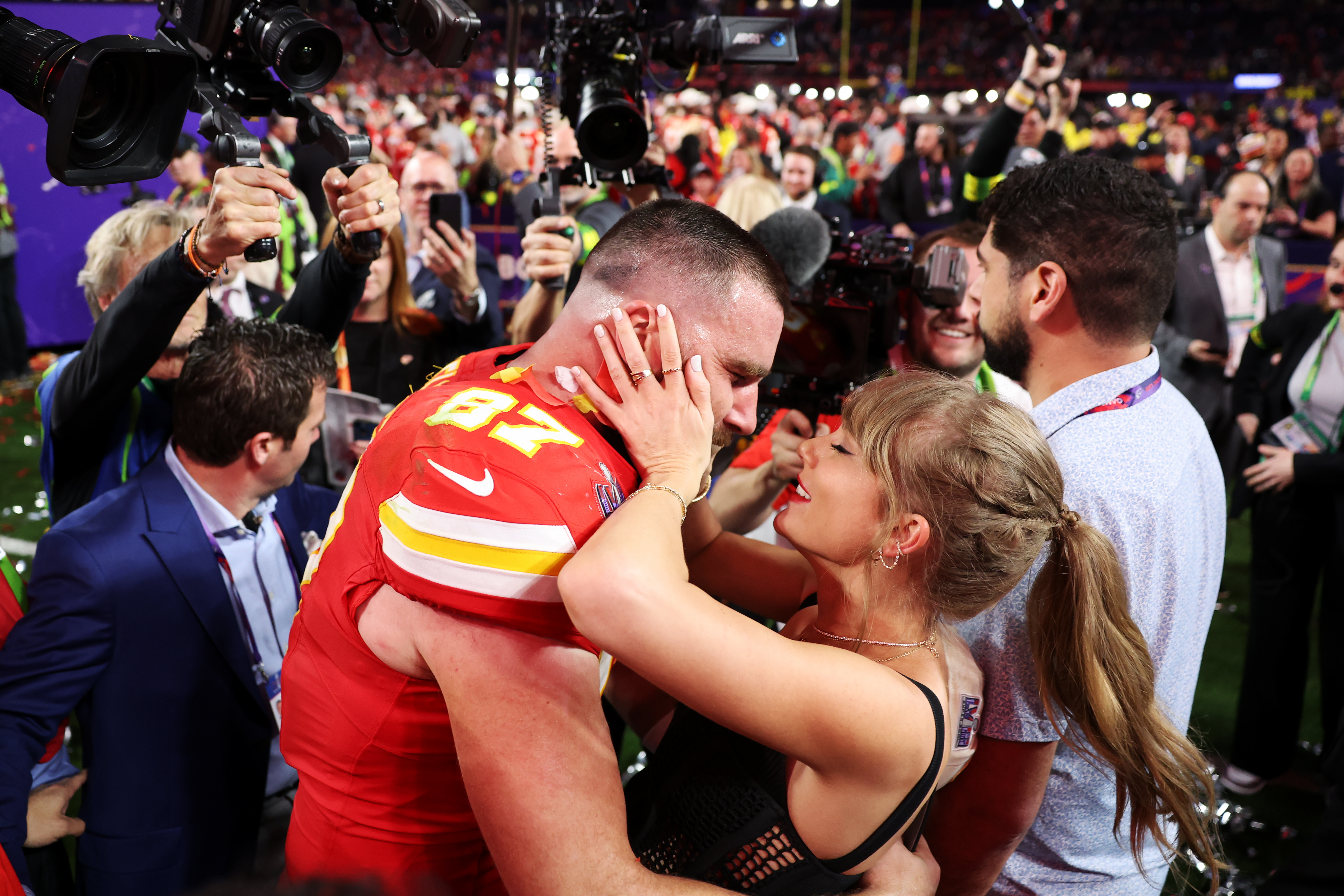 Taylor Swift and Travis Kelce hugging on the football field after the Kansas City Chiefs won Super Bowl LVIII