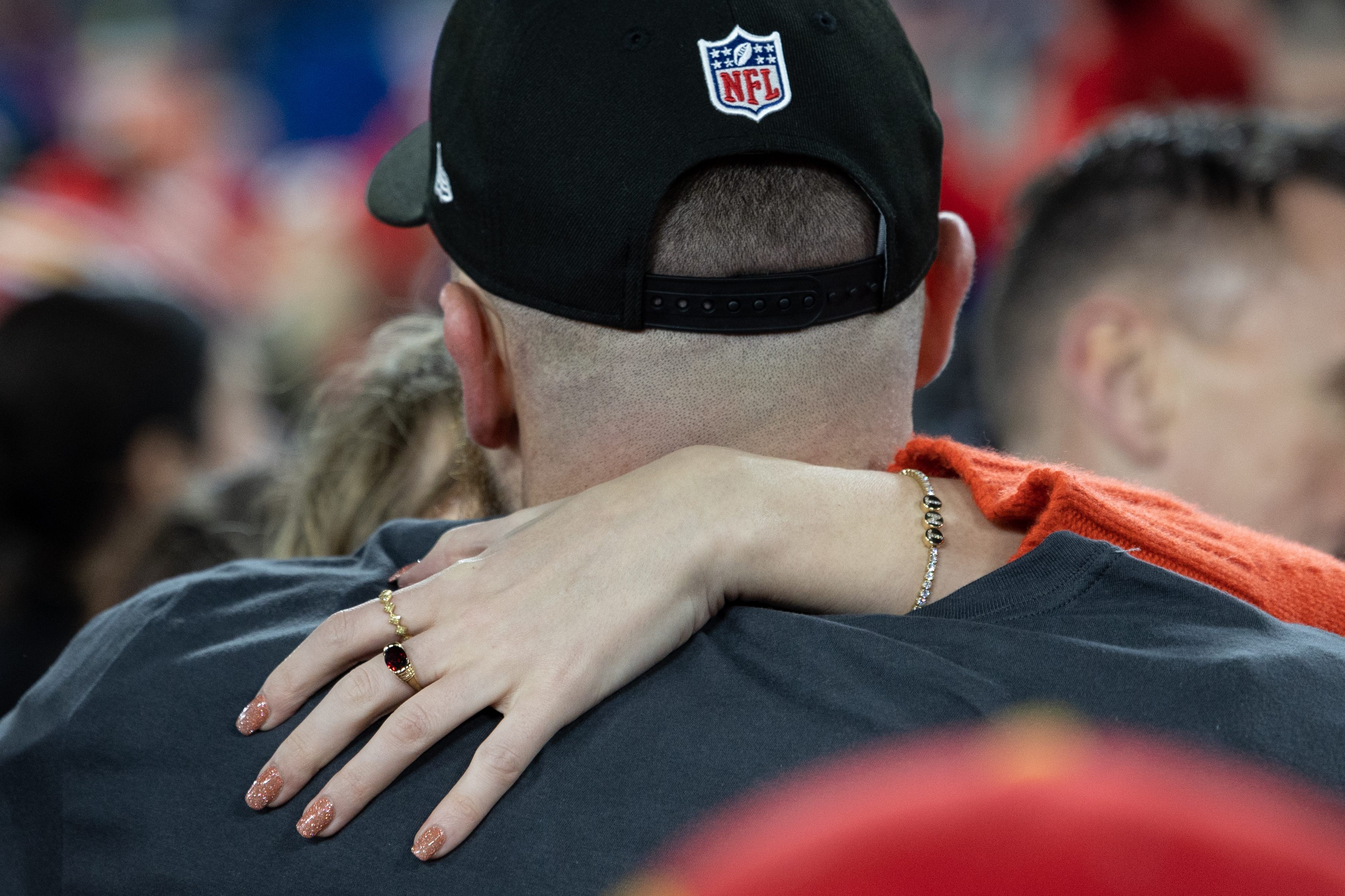 Click to open the image gallery Taylor Swift hugging Travis Kelce on the field after the AFC Championship game, wearing a Wove bracelet