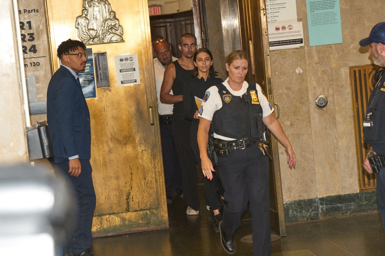 Angela Nikolau and Ivan Beerkus walking outside New York City Criminal Court after their arraignment