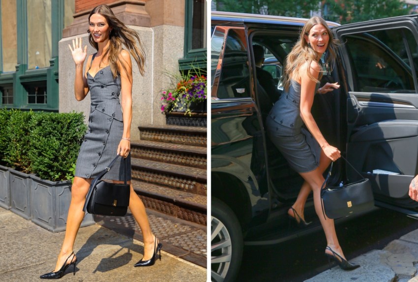 Karlie Kloss waving while walking on a NYC sidewalk in a sleeveless gray button-front dress, black slingback heels, and carrying a black leather bag.