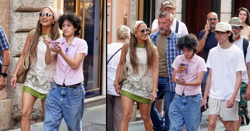 Jennifer Lopez walking on a Rome street with her two teenage twins, surrounded by a crowd and security.