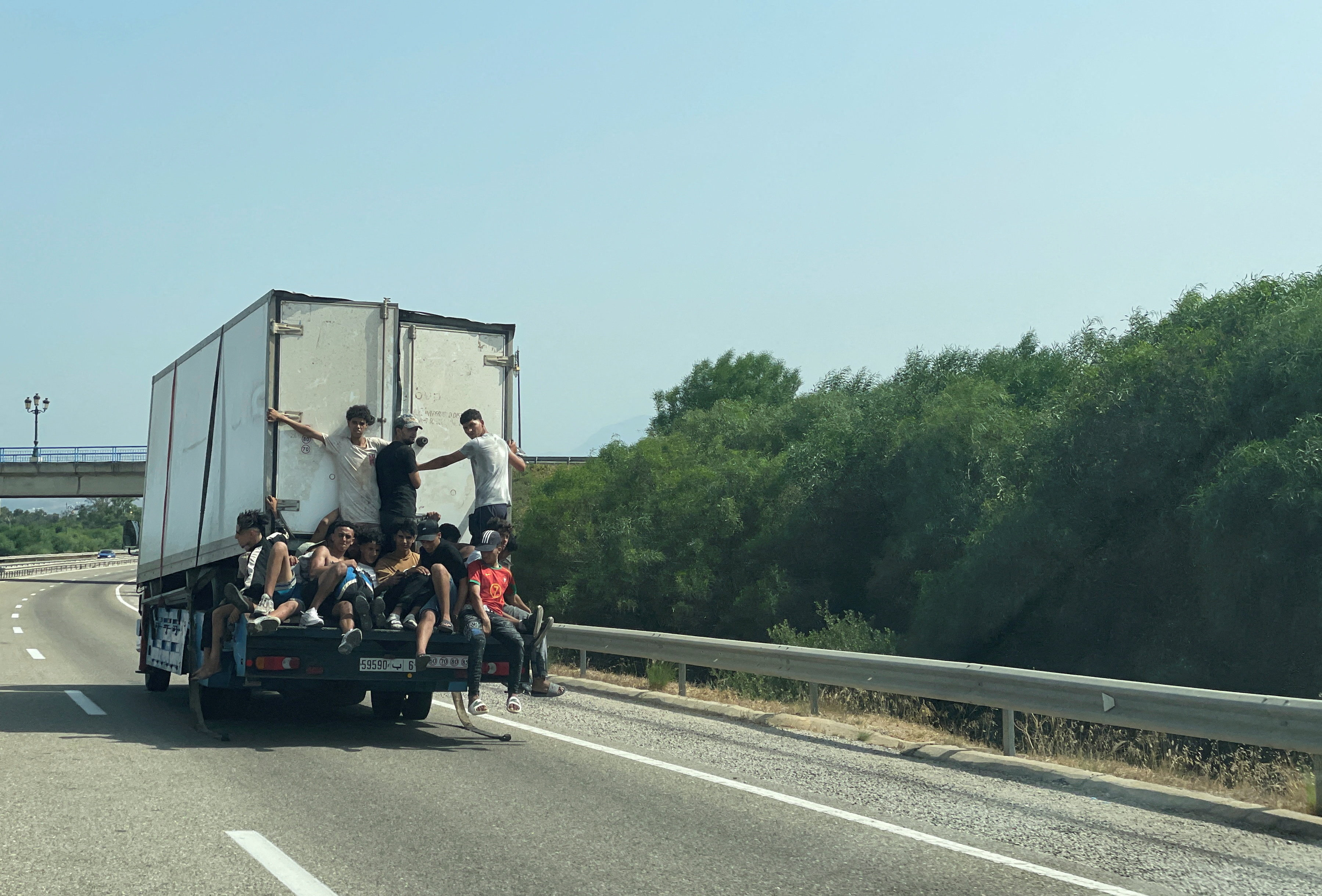 Migrants riding on a truck near Fnideq, Morocco, waiting to cross into the Spanish enclave of Ceuta