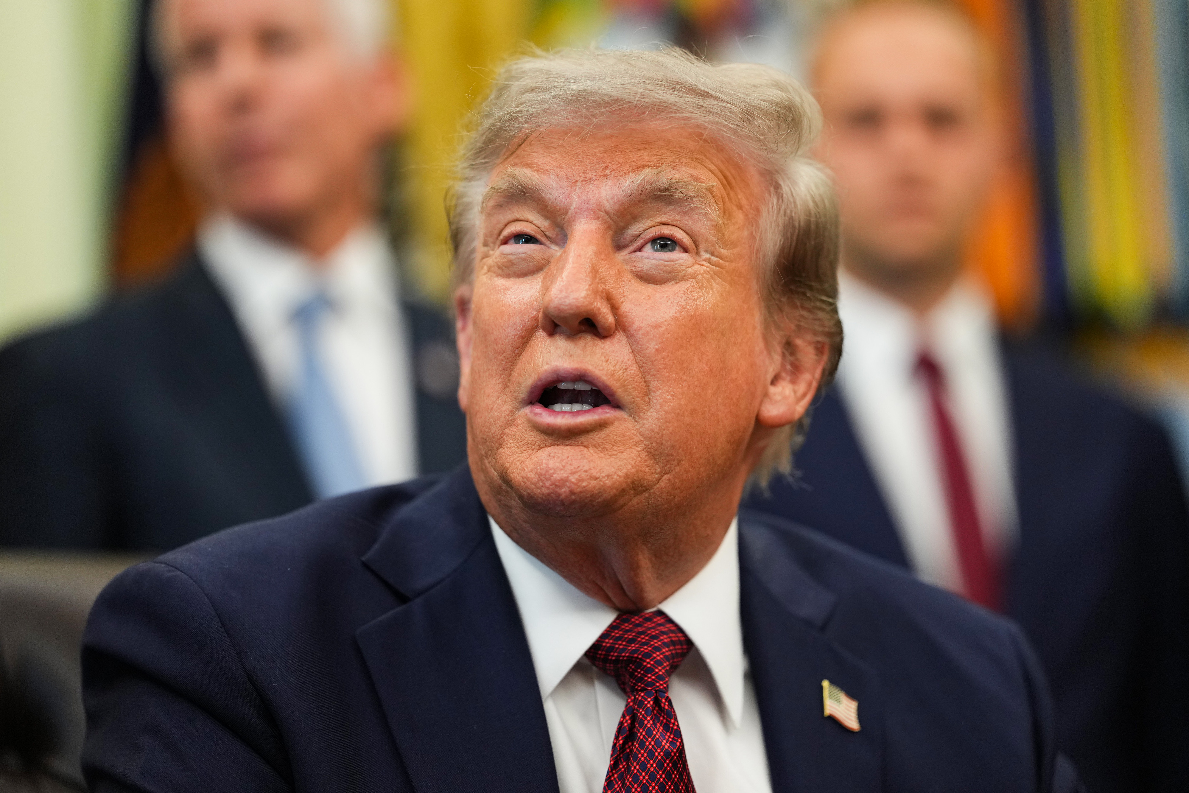 President Donald Trump speaking at a desk in the Oval Office at the White House