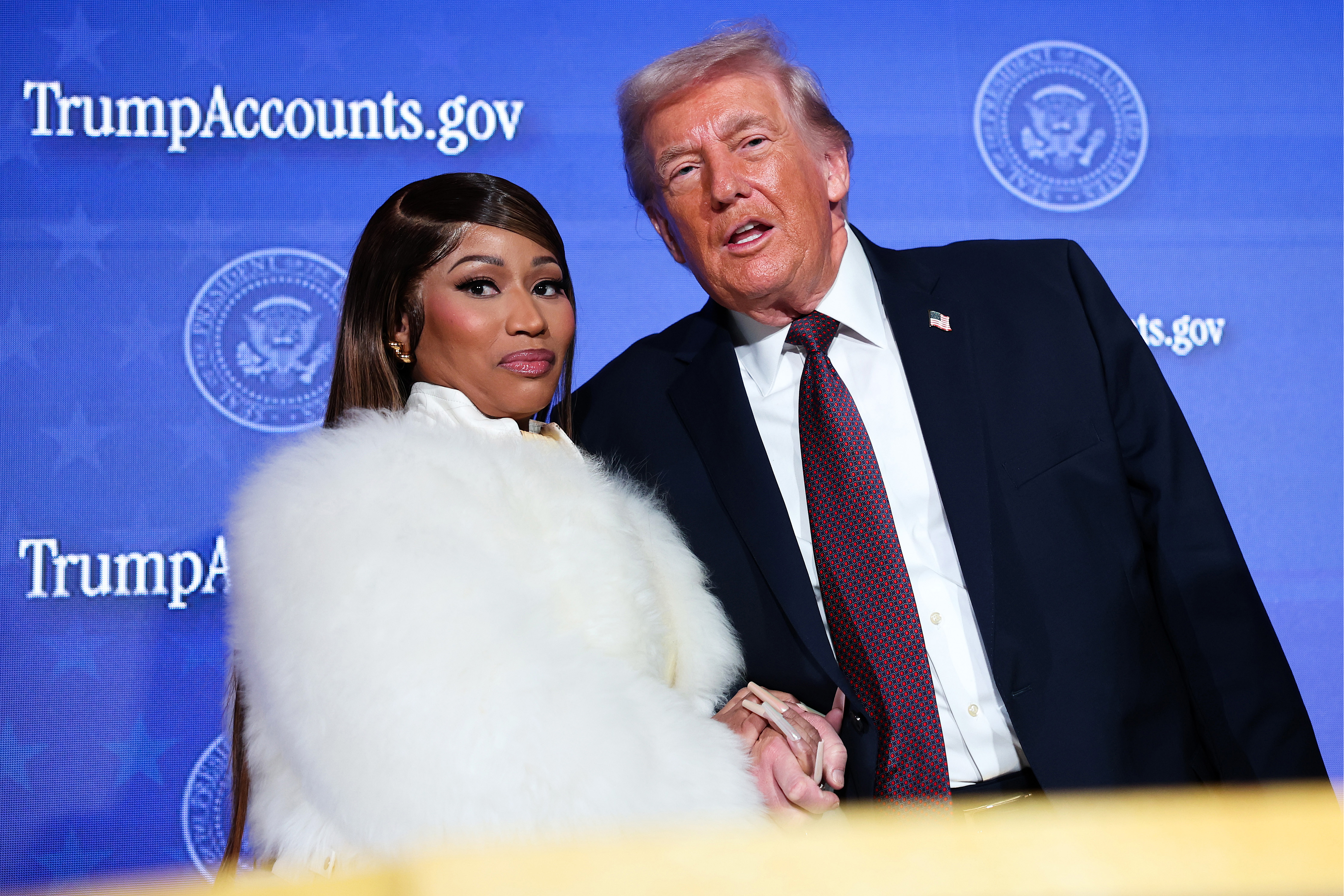 Click to open the image gallery Nicki Minaj and President Donald Trump standing together on stage at the Trump Accounts Summit in Washington, D.C.