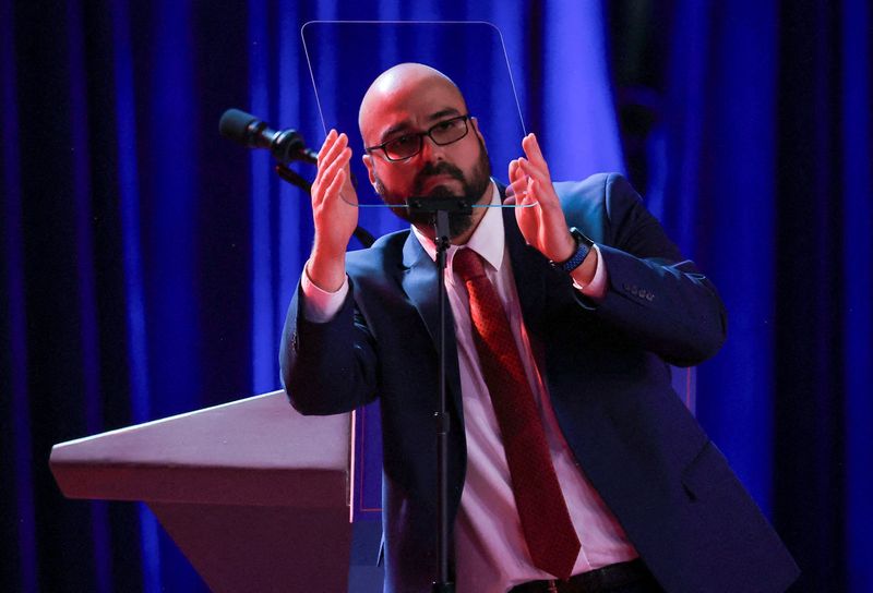 A man checking a teleprompter at the Palm Beach County Convention Center before Trump's 2024 election night speech