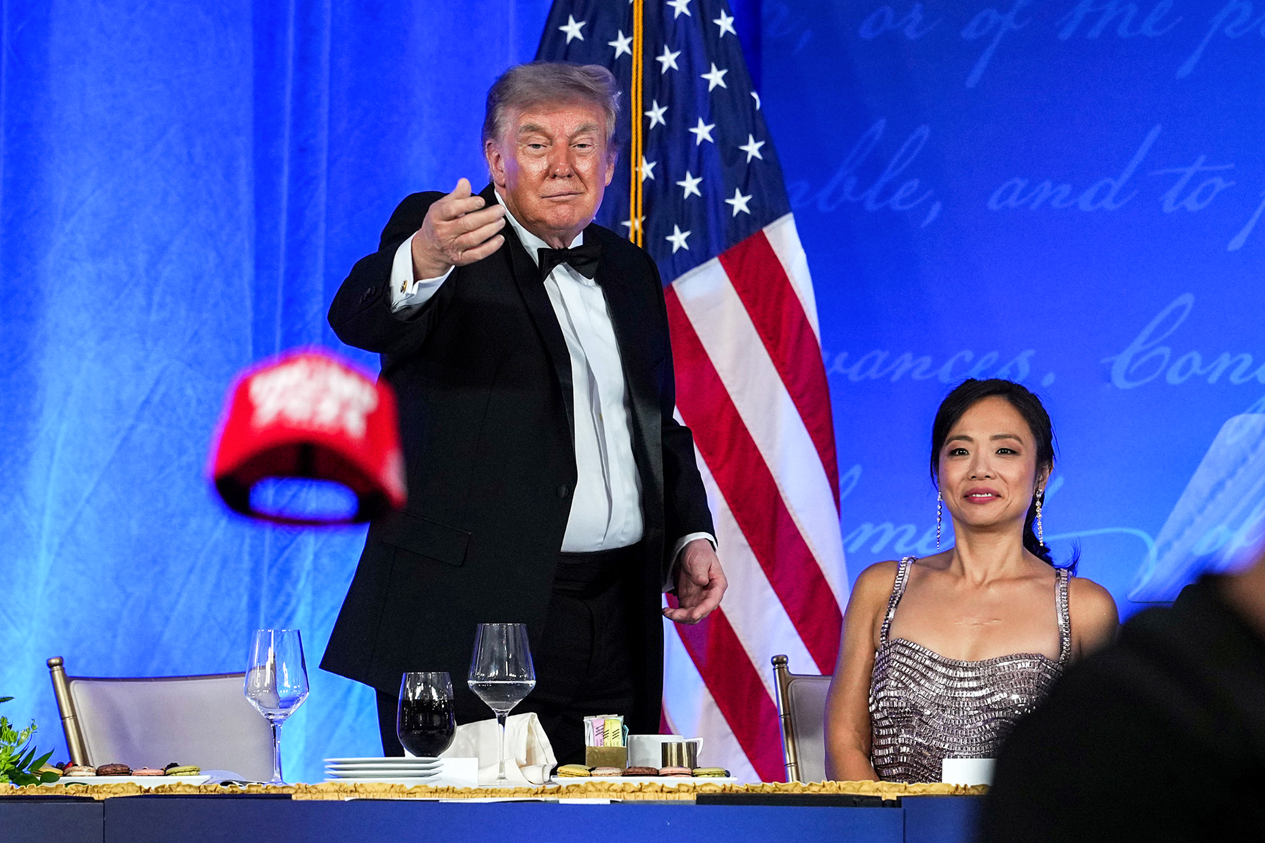 President Trump tossing a TRUMP 2028 hat to an attendee at the White House Correspondents' Dinner at the Waldorf Astoria
