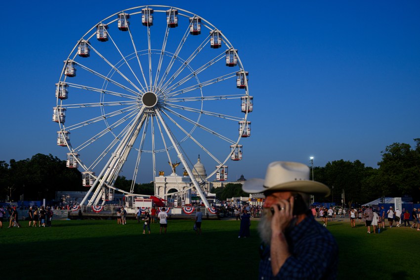 People walking near a Ferris wheel at the Great American State Fair on the National Mall in Washington, D.C.
