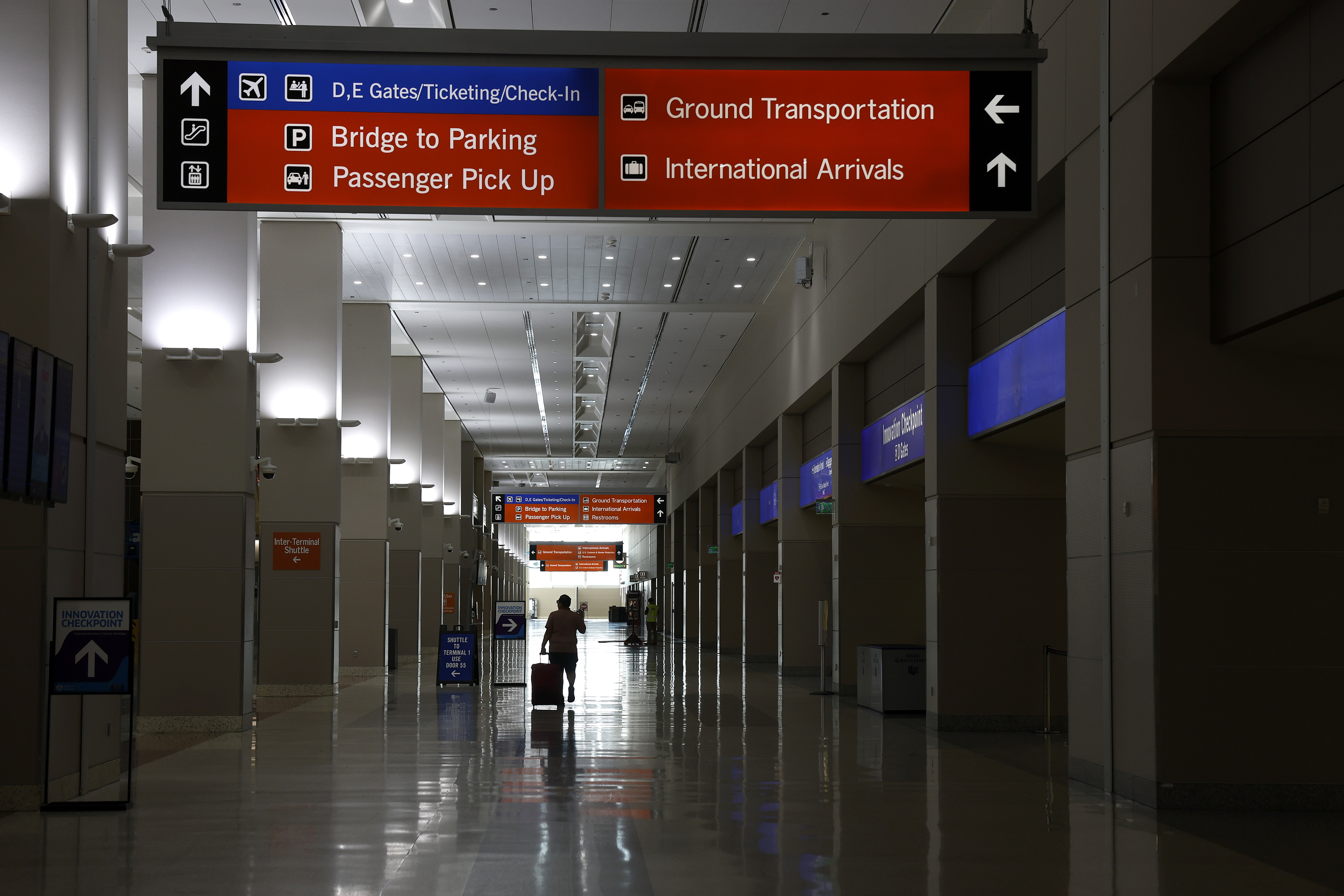 A lone traveler walks through a nearly empty terminal at Harry Reid International Airport in Las Vegas.