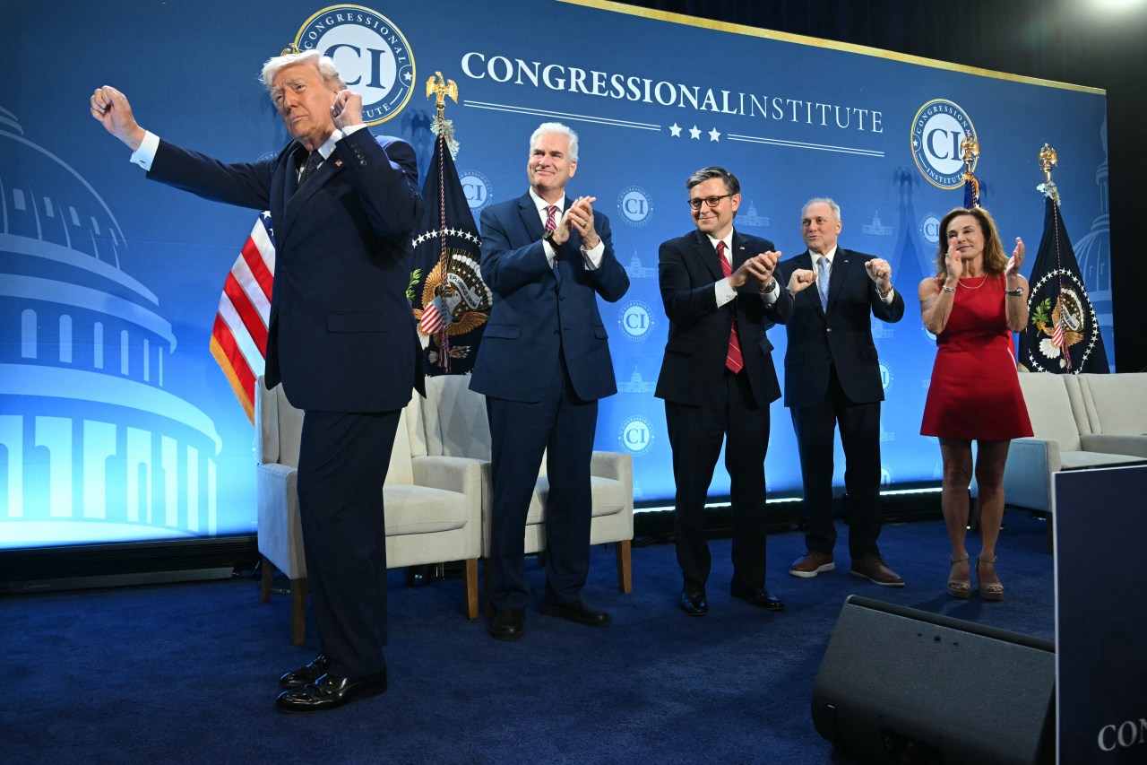 President Trump spreads his arms dancing on stage while four House Republican leaders clap behind him at the Congressional Institute event at Trump National Doral.