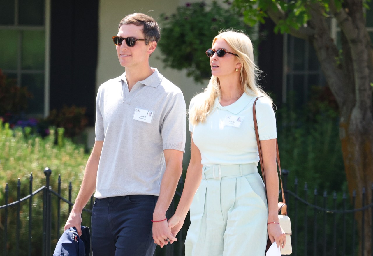 Jared Kushner and Ivanka Trump wearing sunglasses and name badges, holding hands while walking outdoors at the Sun Valley Conference.