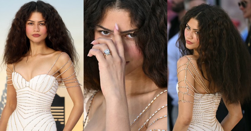 Woman with curly dark hair wearing a gold baguette crystal shoulder piece holds her hand near her face, showing a large diamond ring.