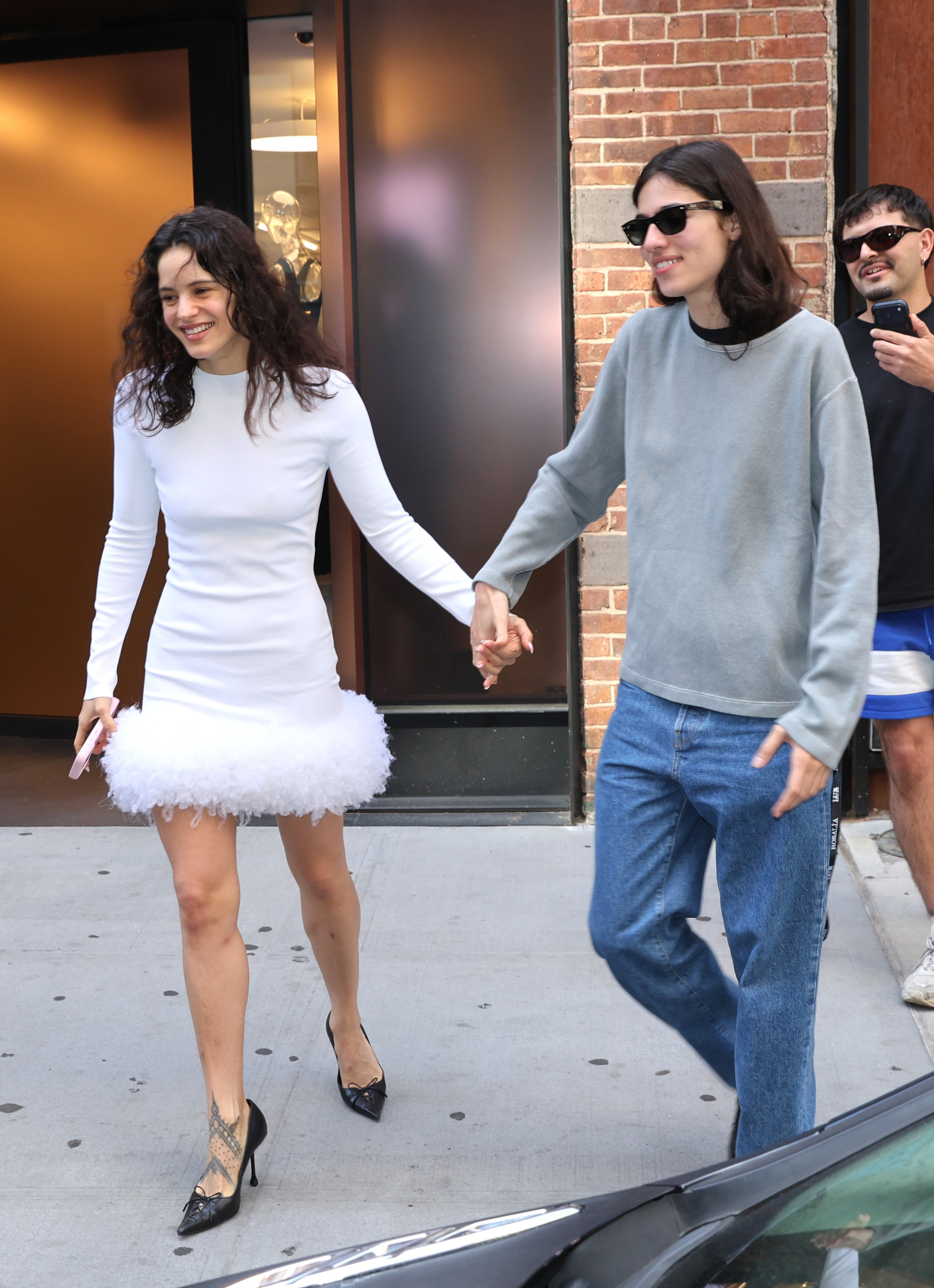 Rosalía and Loli Bahia walking together outside a New York City hotel