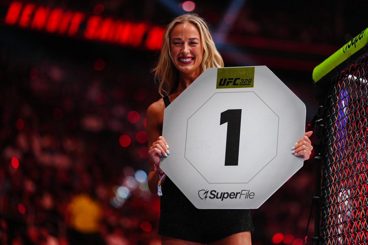 Sophie Cunningham holding a round card as an Octagon Girl during a lightweight bout at UFC 329