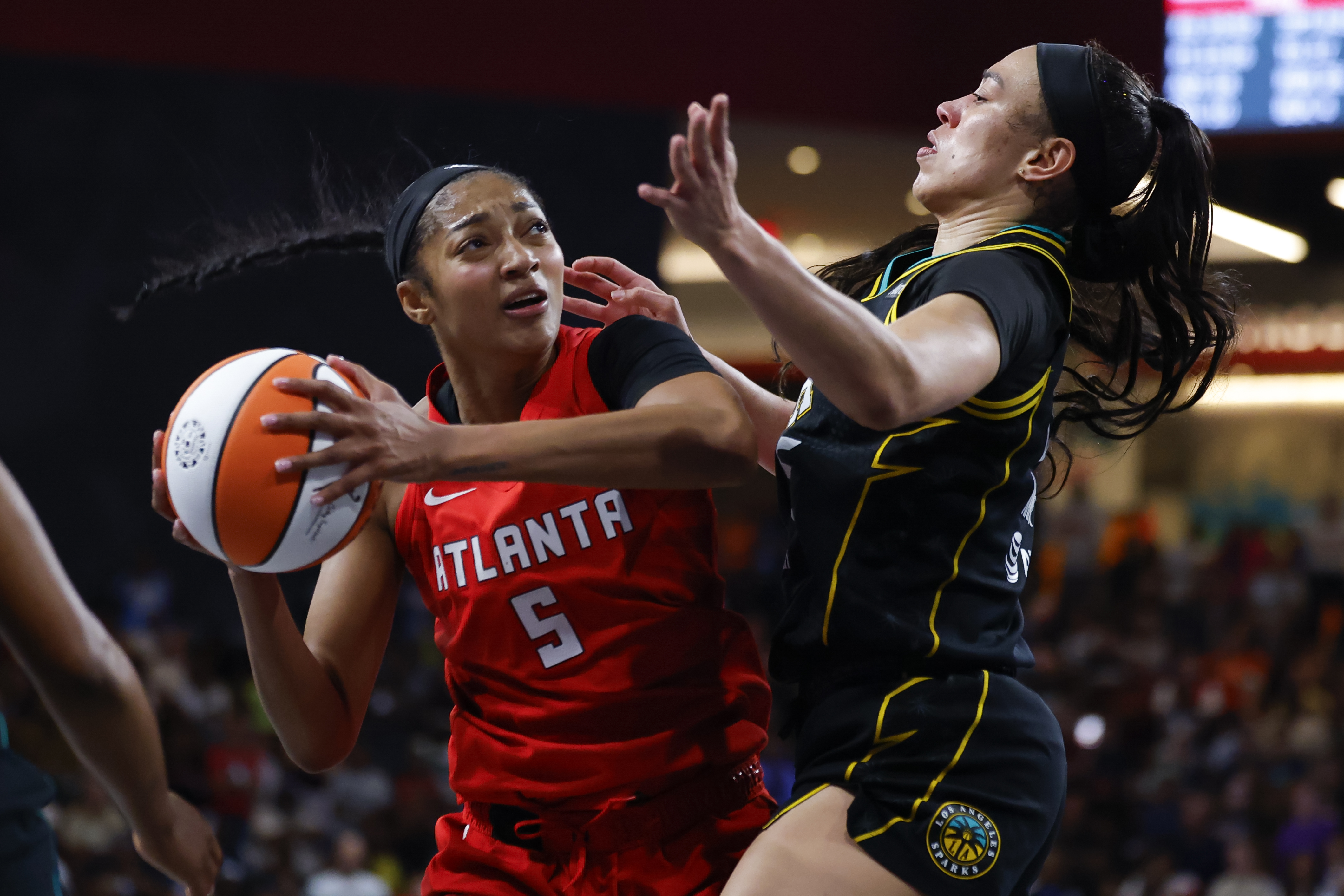 Angel Reese of the Atlanta Dream driving to the basket against Dearica Hamby of the Los Angeles Sparks during a WNBA game