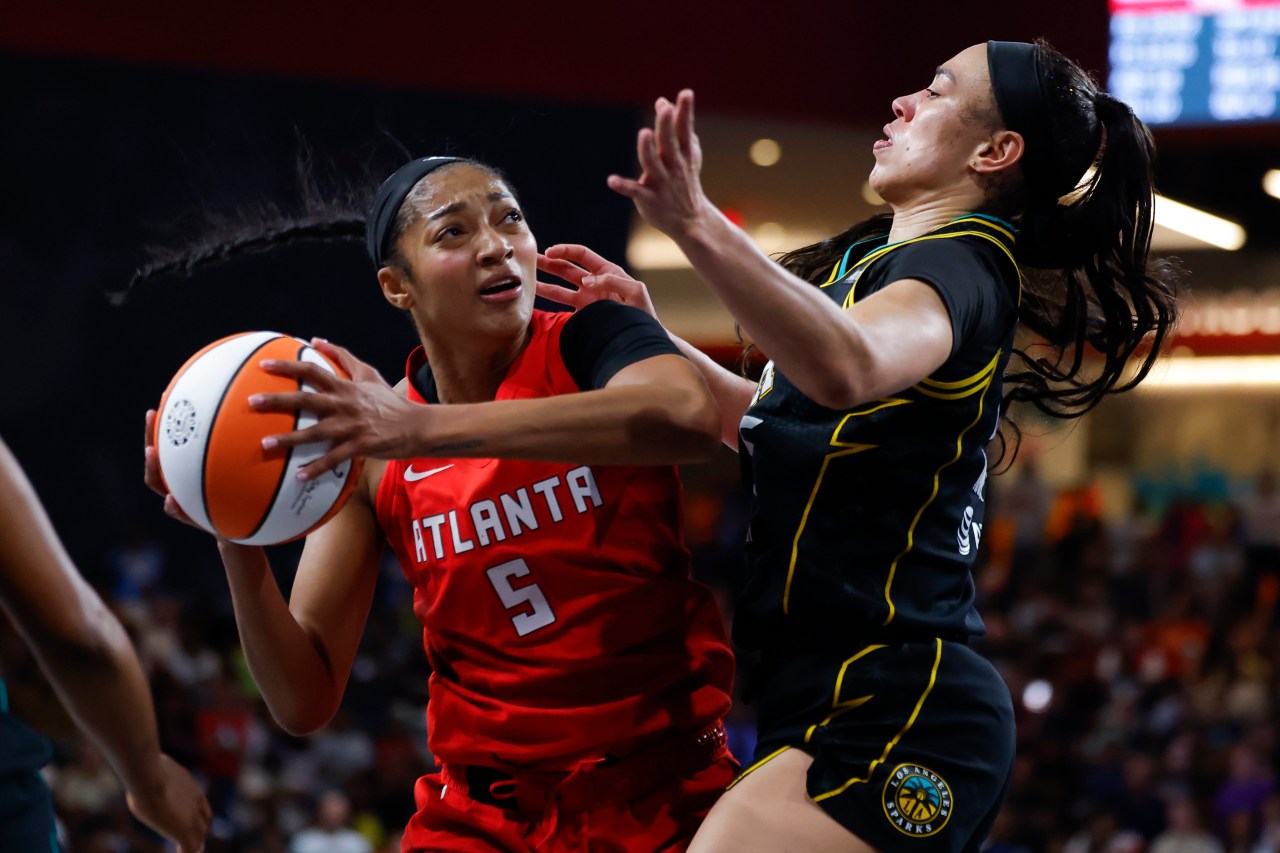 Angel Reese of the Atlanta Dream driving to the basket against Dearica Hamby of the Los Angeles Sparks during a WNBA game
