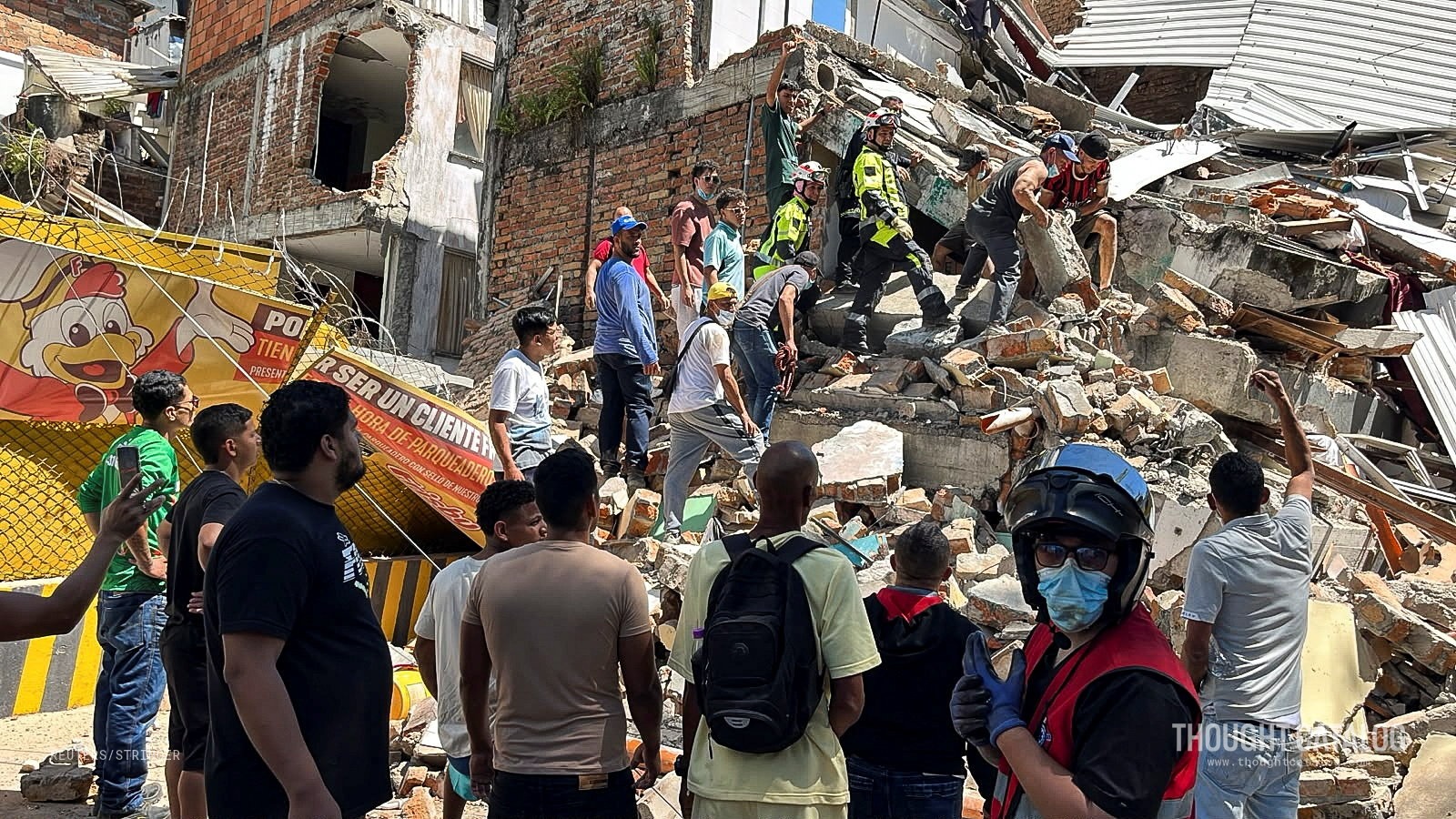 Rescue workers digging through collapsed building rubble after an earthquake in western Colombia