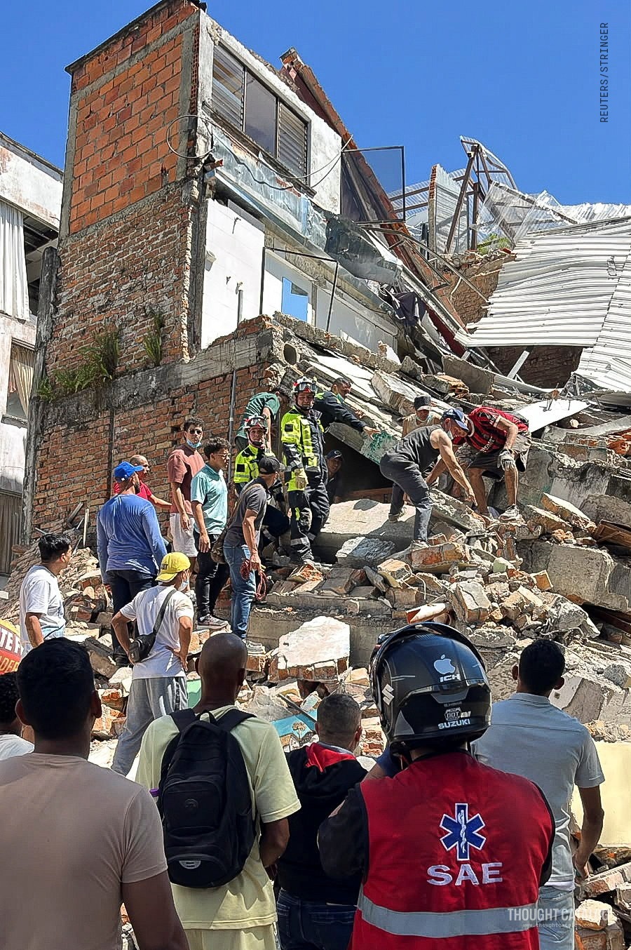 Rescue workers searching through collapsed building rubble after a major earthquake in western Colombia