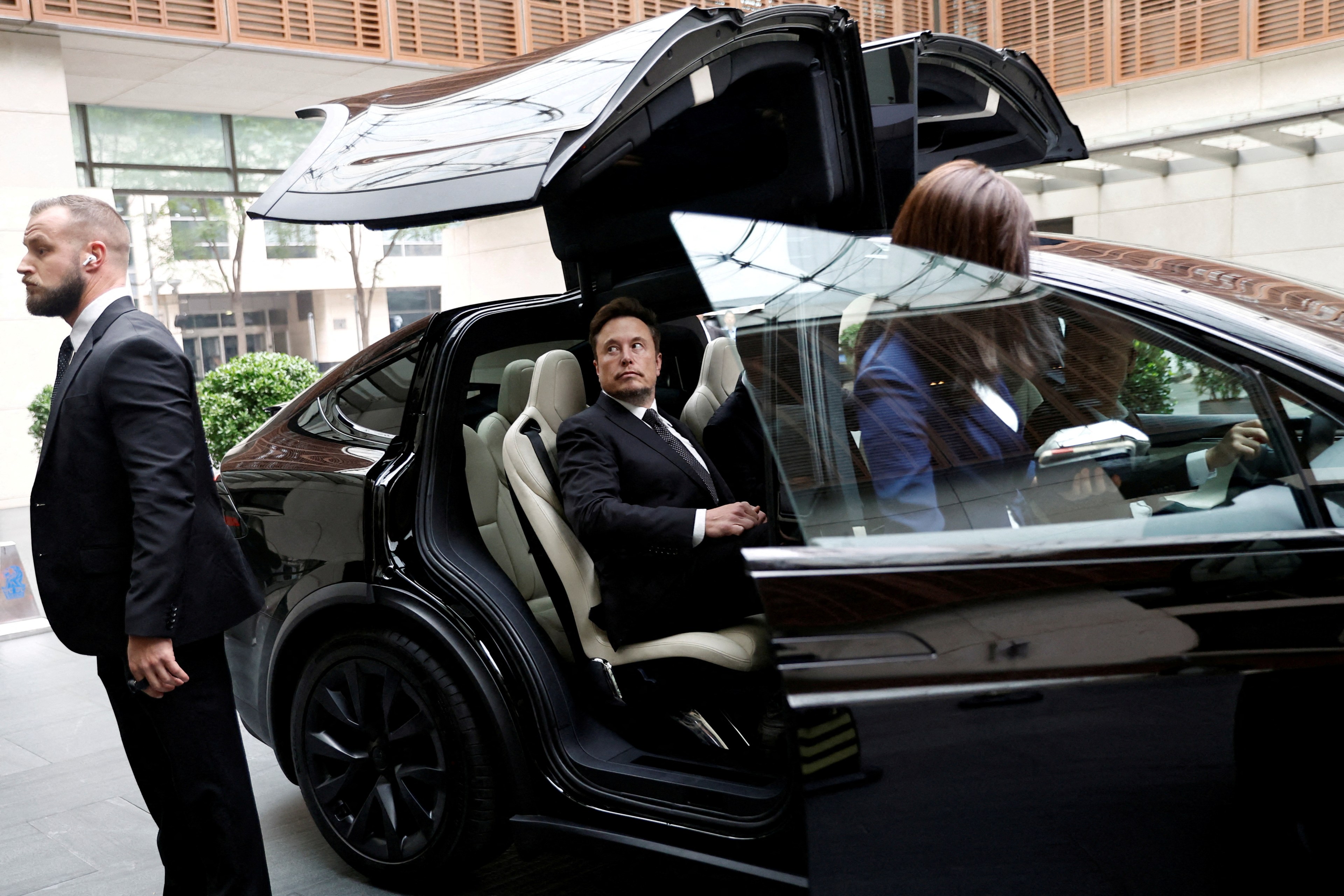 Elon Musk getting into a Tesla car outside a hotel in Beijing, China