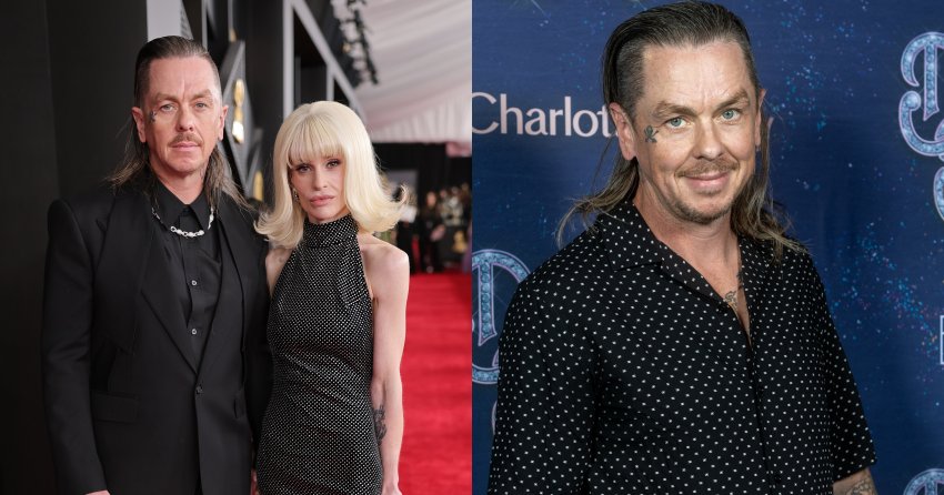 Sid Wilson in a black suit and Kelly Osbourne in a black sparkly halter gown pose together on the Grammy Awards red carpet.
