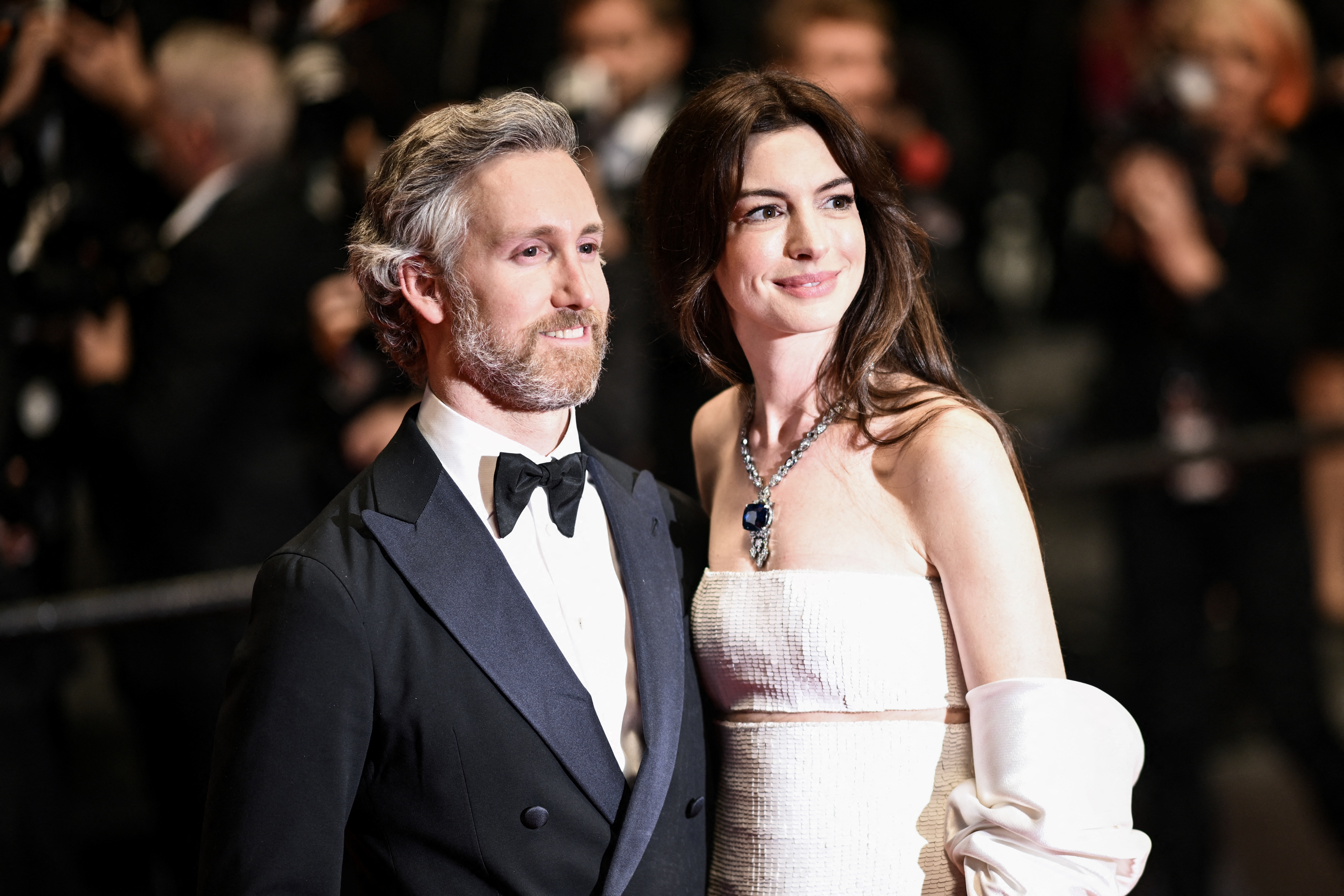 Anne Hathaway and Adam Shulman posing outside the Festival Palace at the 75th Cannes Film Festival