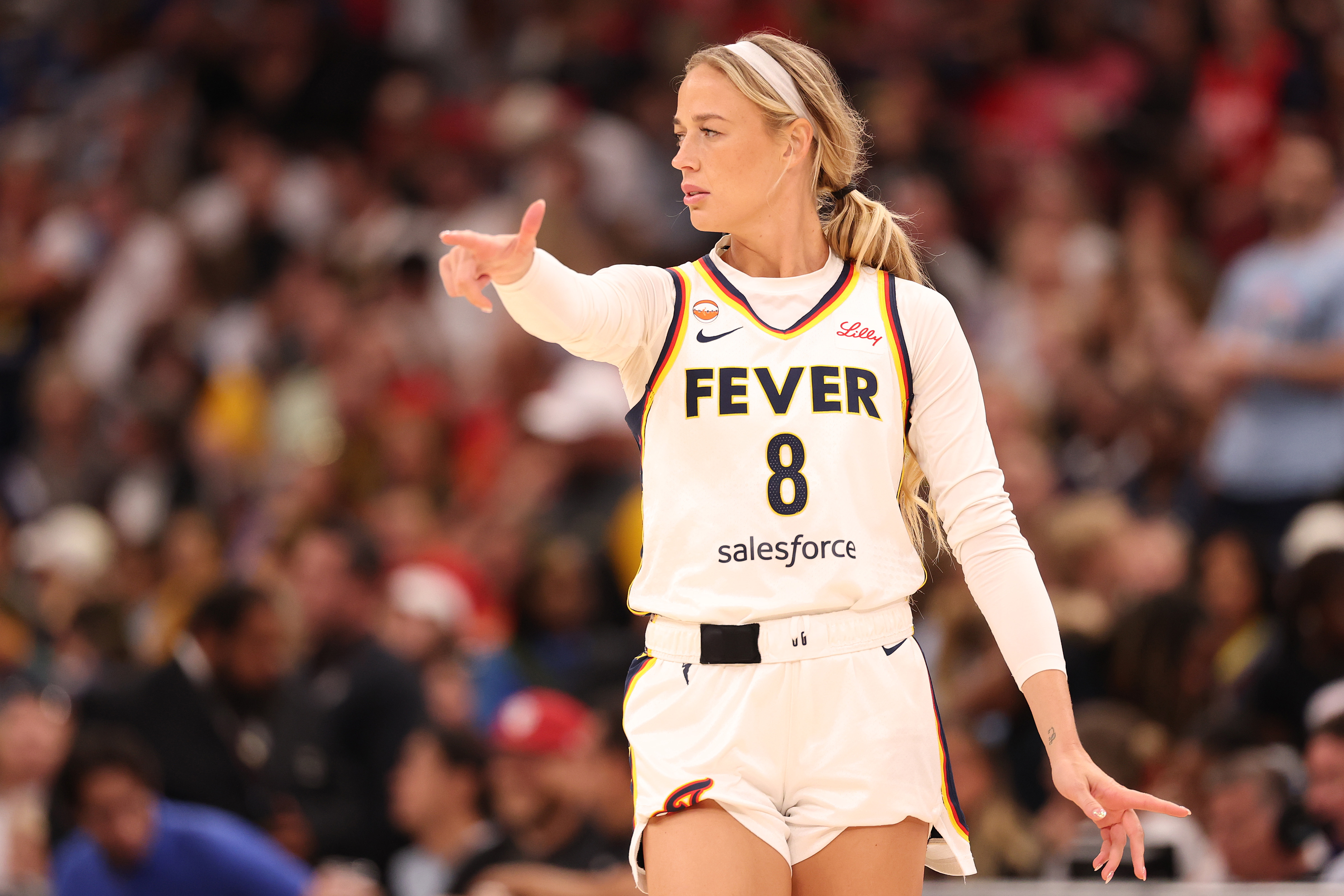 Indiana Fever player Sophie Cunningham, wearing number 8, points while reacting during a WNBA game against the Chicago Sky.