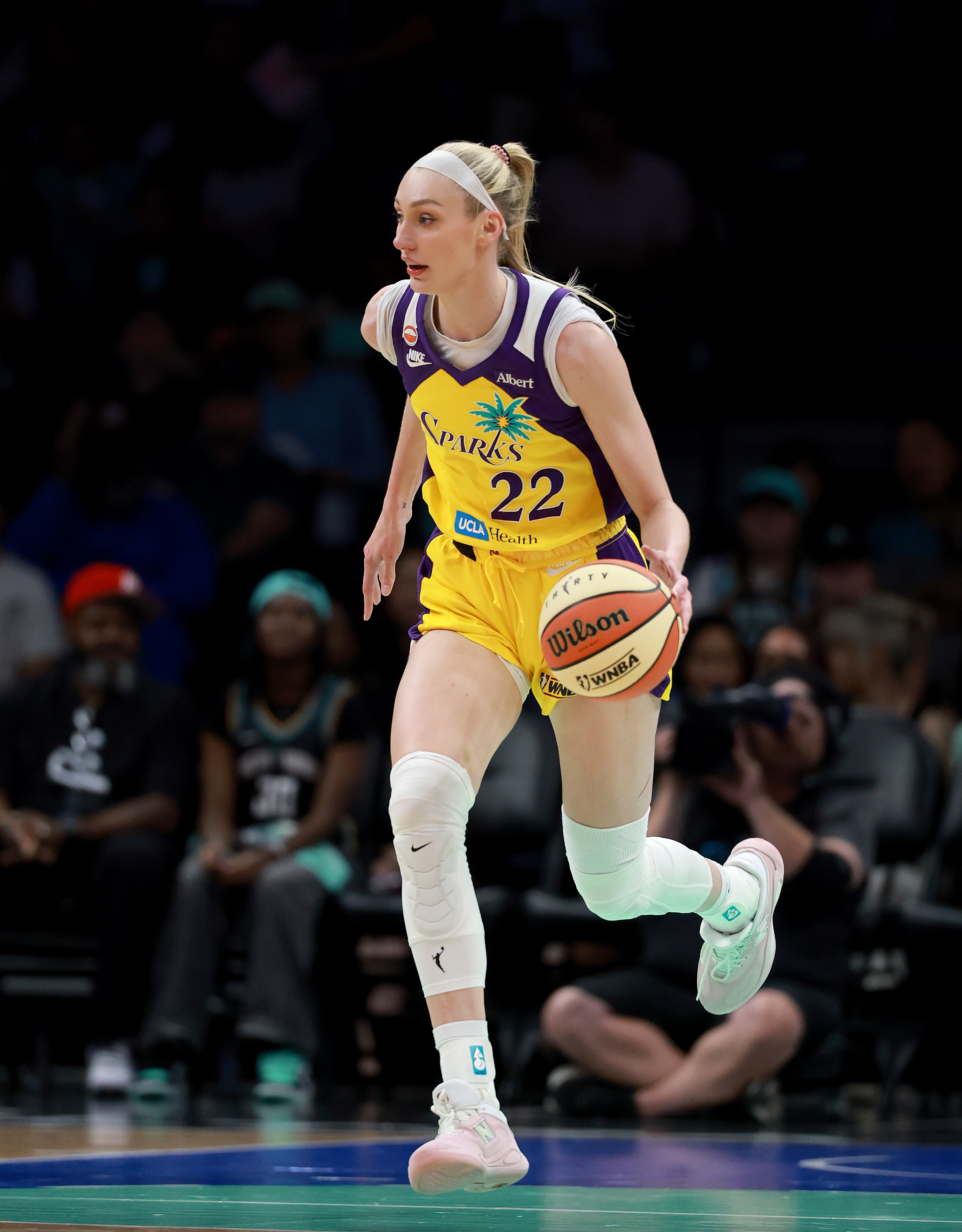 Cameron Brink #22 in a yellow and purple LA Sparks uniform dribbles a Wilson WNBA basketball during a game at Barclays Center.