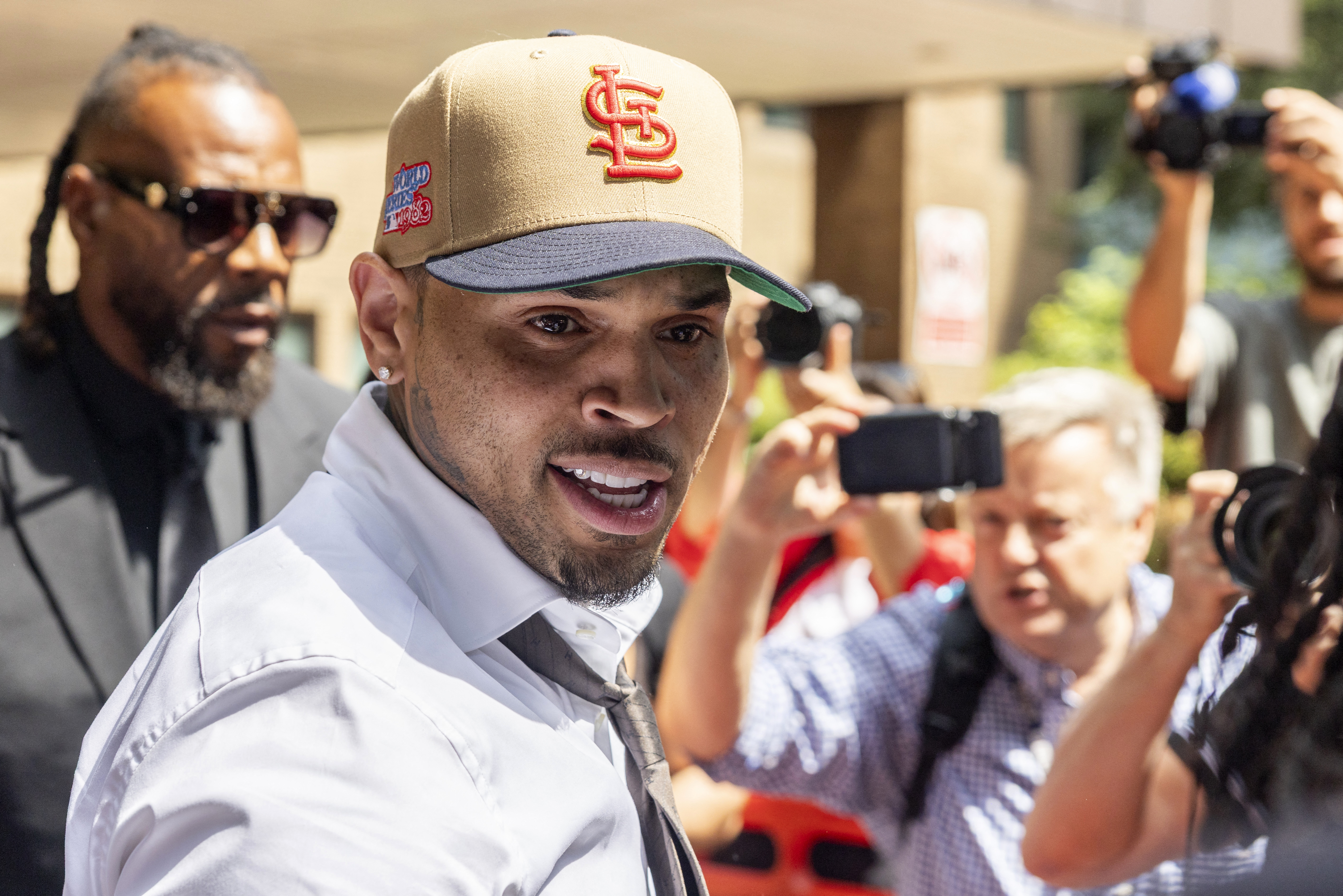 Chris Brown in a beige suit and dark tie outside Southwark Crown Court in London