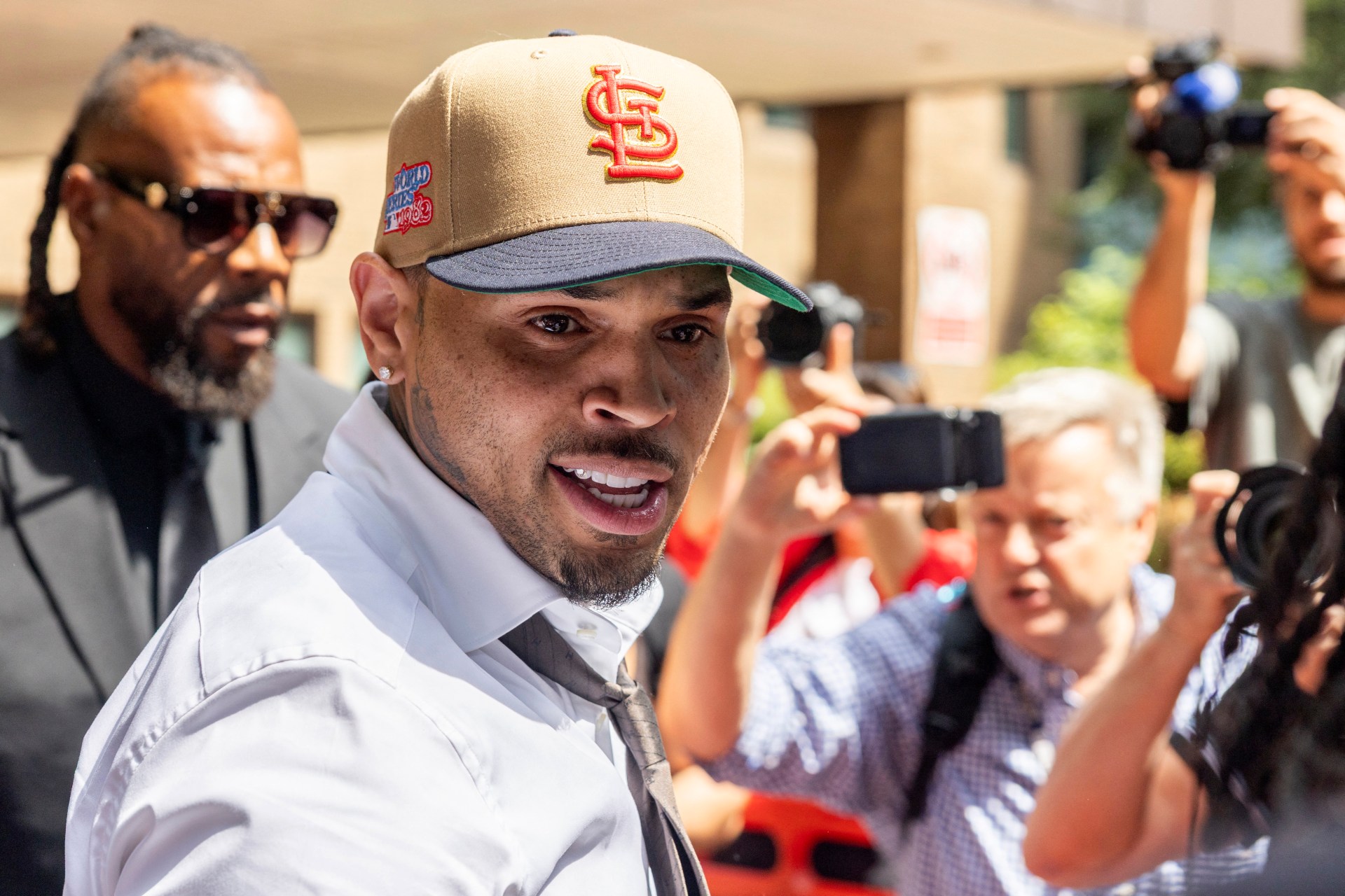 Chris Brown in a beige suit and dark tie outside Southwark Crown Court in London