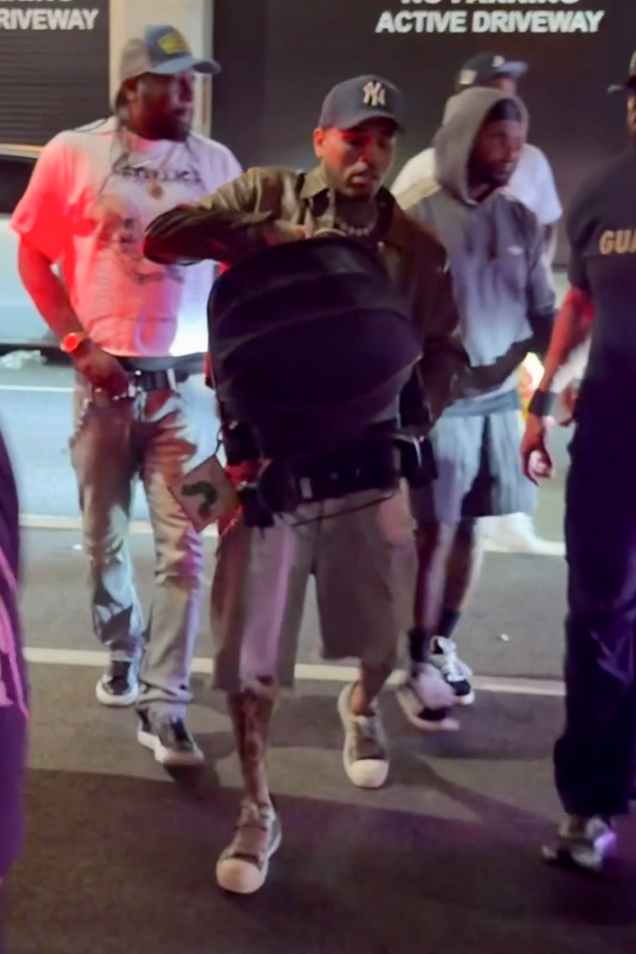 Chris Brown carrying a baby carrier with his infant son outside a venue in New York City's Meatpacking District