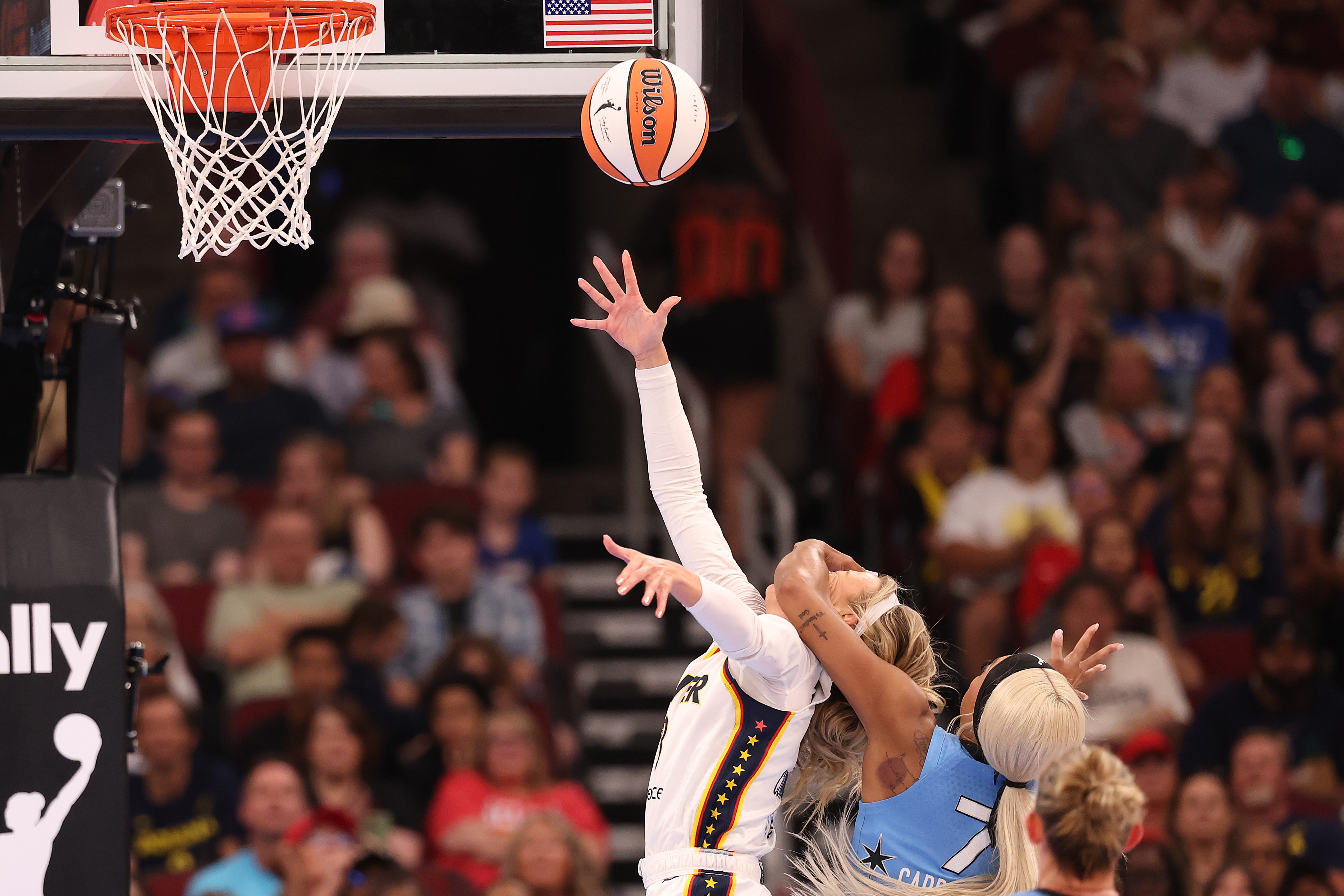 Click to open the image gallery Indiana Fever player Sophie Cunningham reaches for a layup while being fouled by a Chicago Sky defender near the basket.